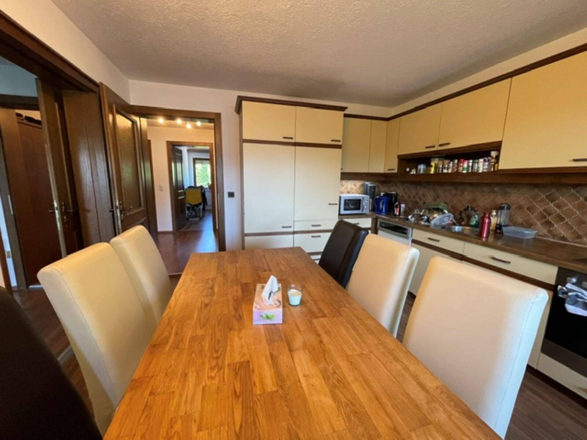 Geräumige Wohnküche mit Esstisch und Zugang zu weiteren Räumen der Wohnung.