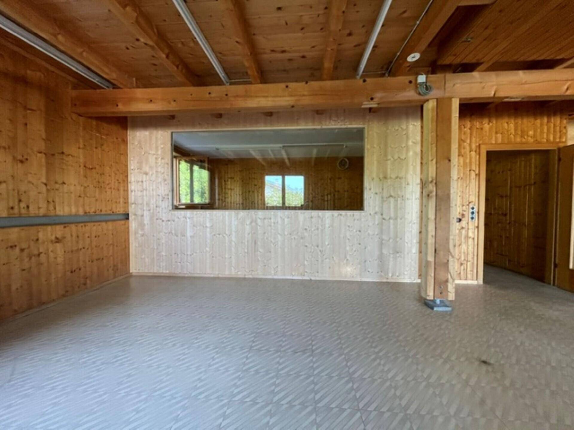 Innenraum mit Holzvertäfelung, Holzbalken und einer großen Spiegelfläche an der Wand.