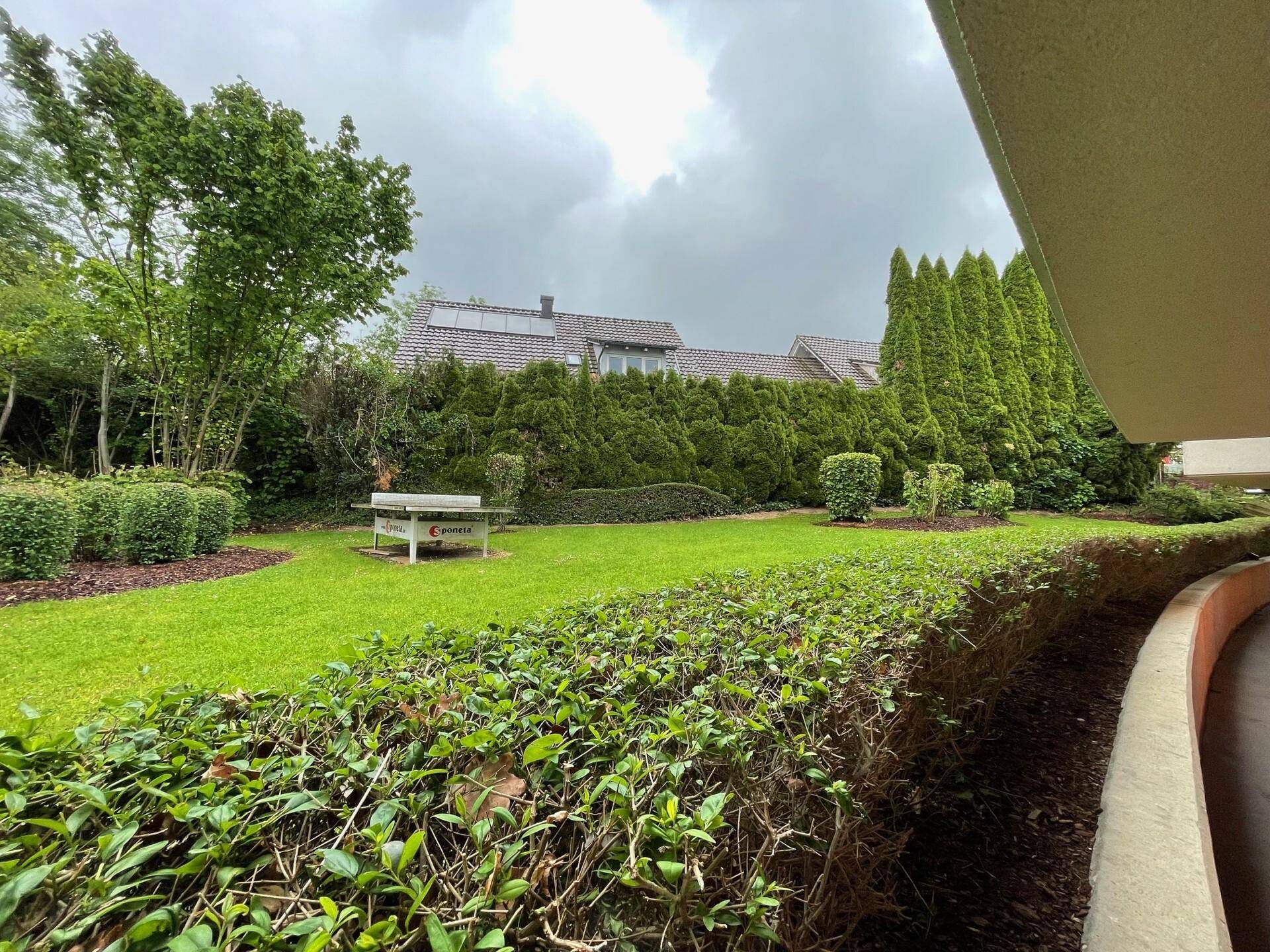 Weitläufiger Garten mit gepflegtem Rasen, Hecken und Bäumen, bietet viel Privatsphäre.