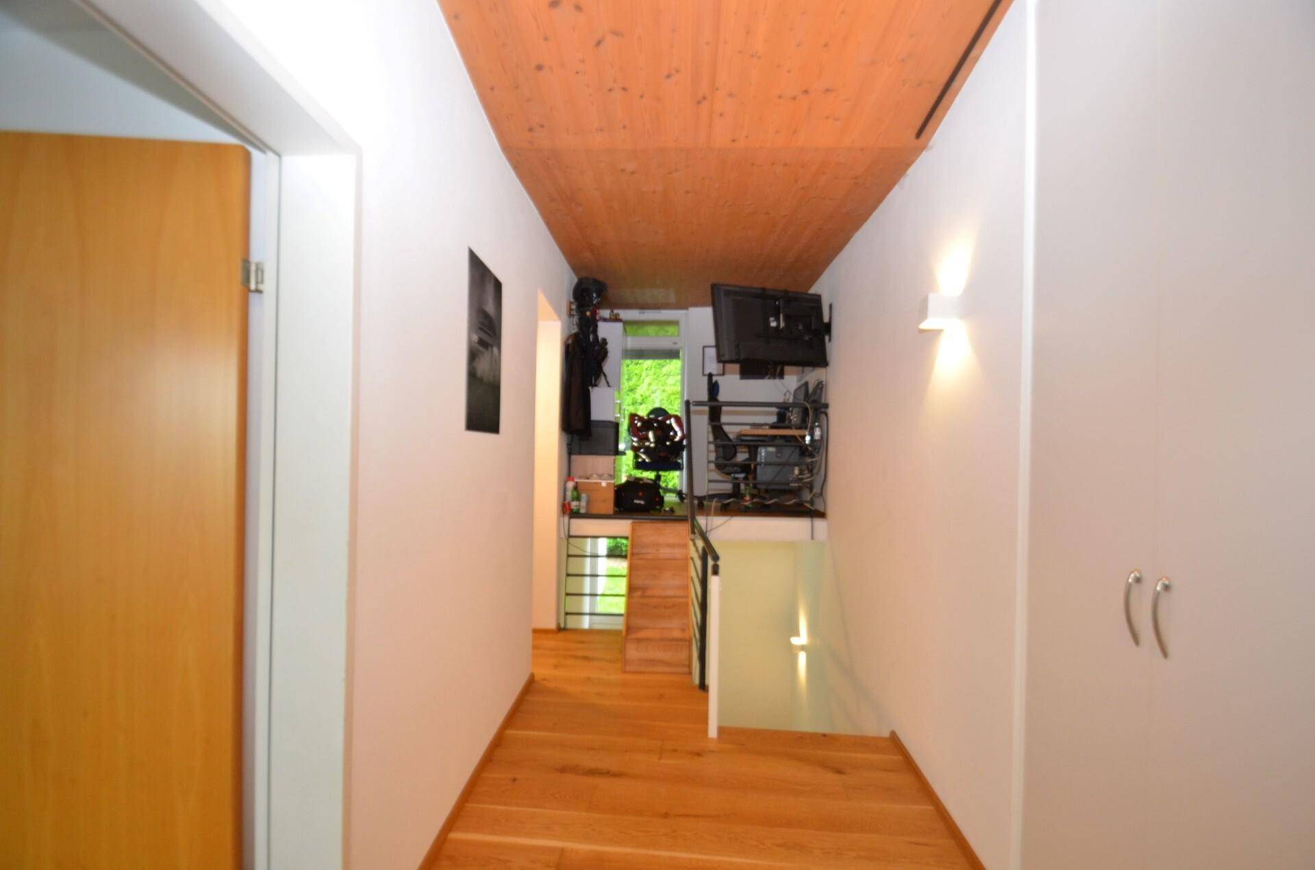 Geräumiger Flur mit Holzboden und Einbauschränken, der den Zugang zu weiteren Räumen ermöglicht.