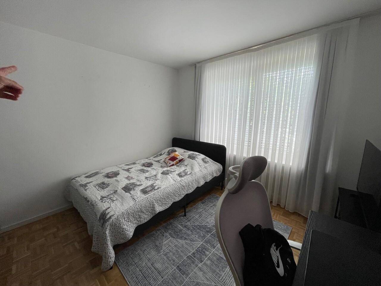 Helles Kinder- oder Gästezimmer mit Einzelbett, Schreibtisch und Parkettboden, ideal für Ruhe und Konzentration.