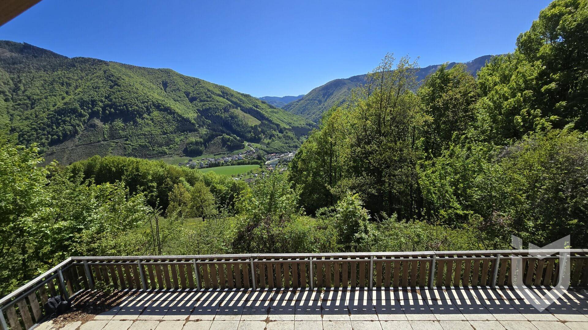 Weitläufige Terrasse mit atemberaubendem Panoramablick auf die umliegende Berglandschaft und das Tal.