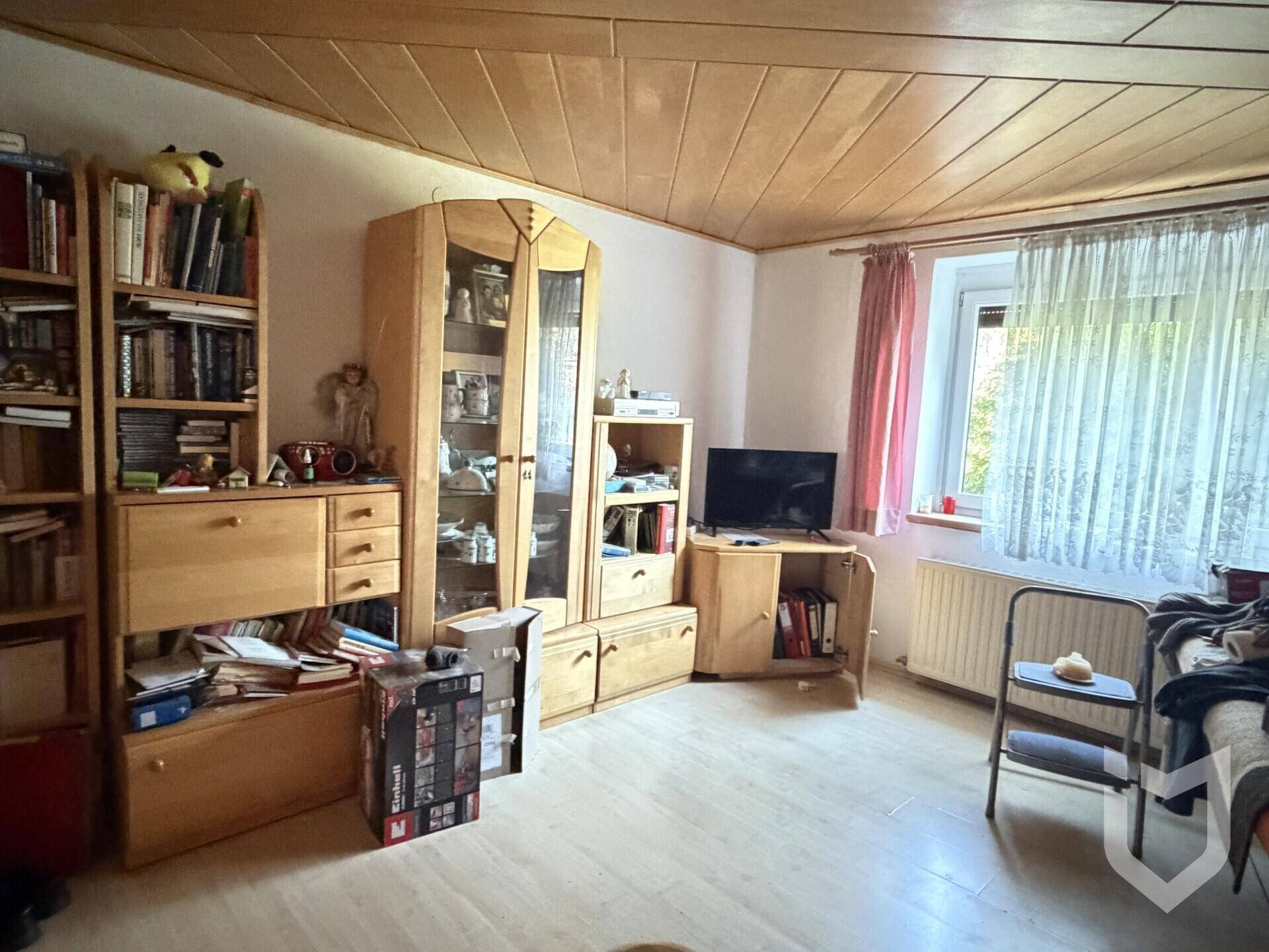 Gemütliches Schlafzimmer mit Holzmöbeln, Holzdecke und Blick ins Grüne.