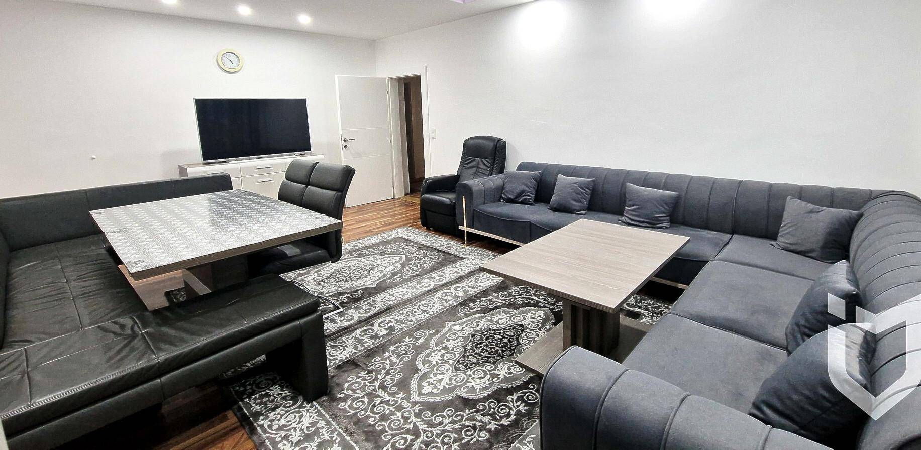Geräumiger Wohn- und Essbereich mit großem Ecksofa, Esstisch und Fernseher.