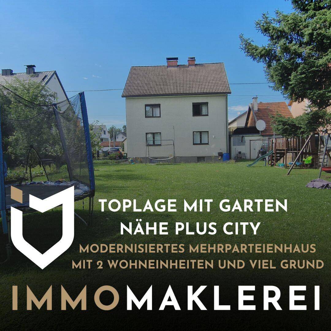 Großer Gartenbereich mit Trampolin und Spielgeräten hinter dem Mehrparteienhaus.