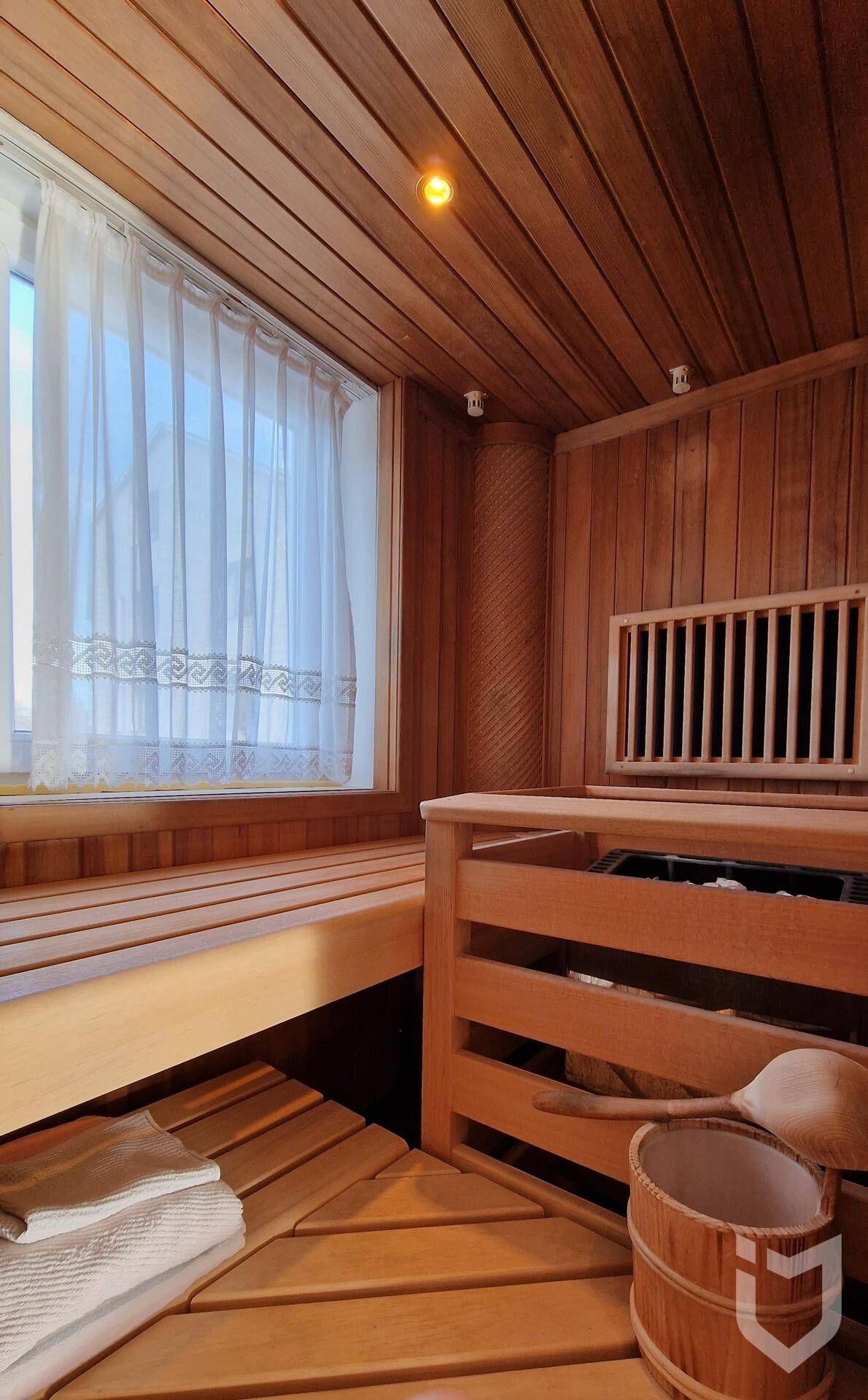 Traditionelle Holzsauna mit Bänken und Fenster, bereit für entspannende Momente.