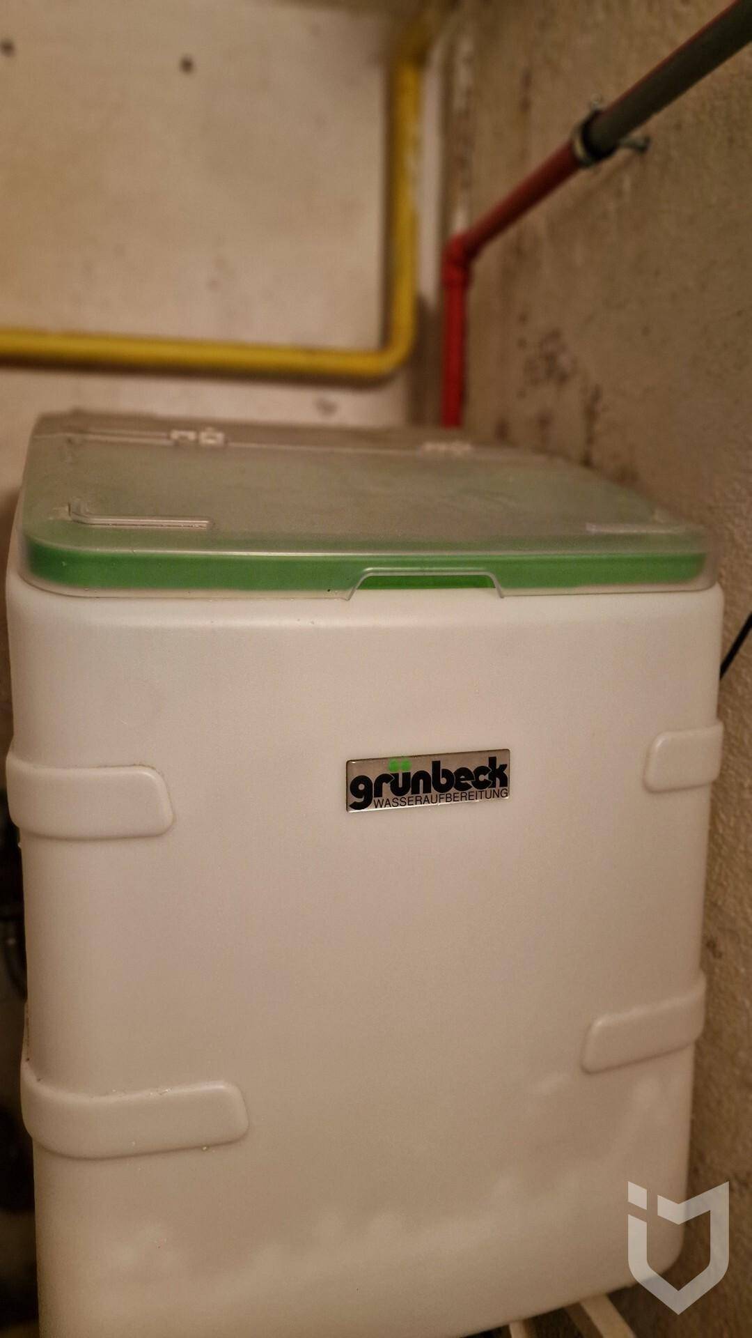 Nahaufnahme einer Grunbeck Wasserenthärtungsanlage in einem Technikraum.