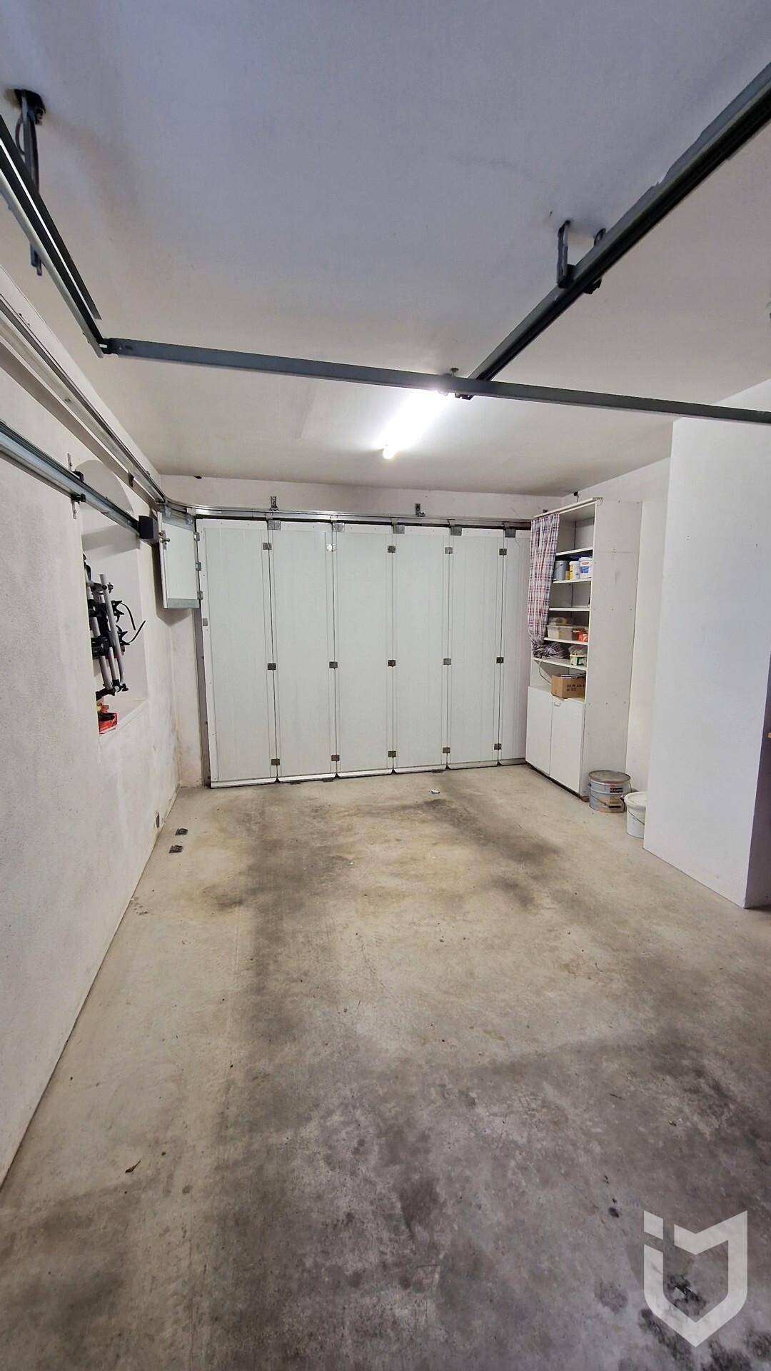 Geräumige Garage mit Betonboden und Sektionaltoren für Fahrzeuge.