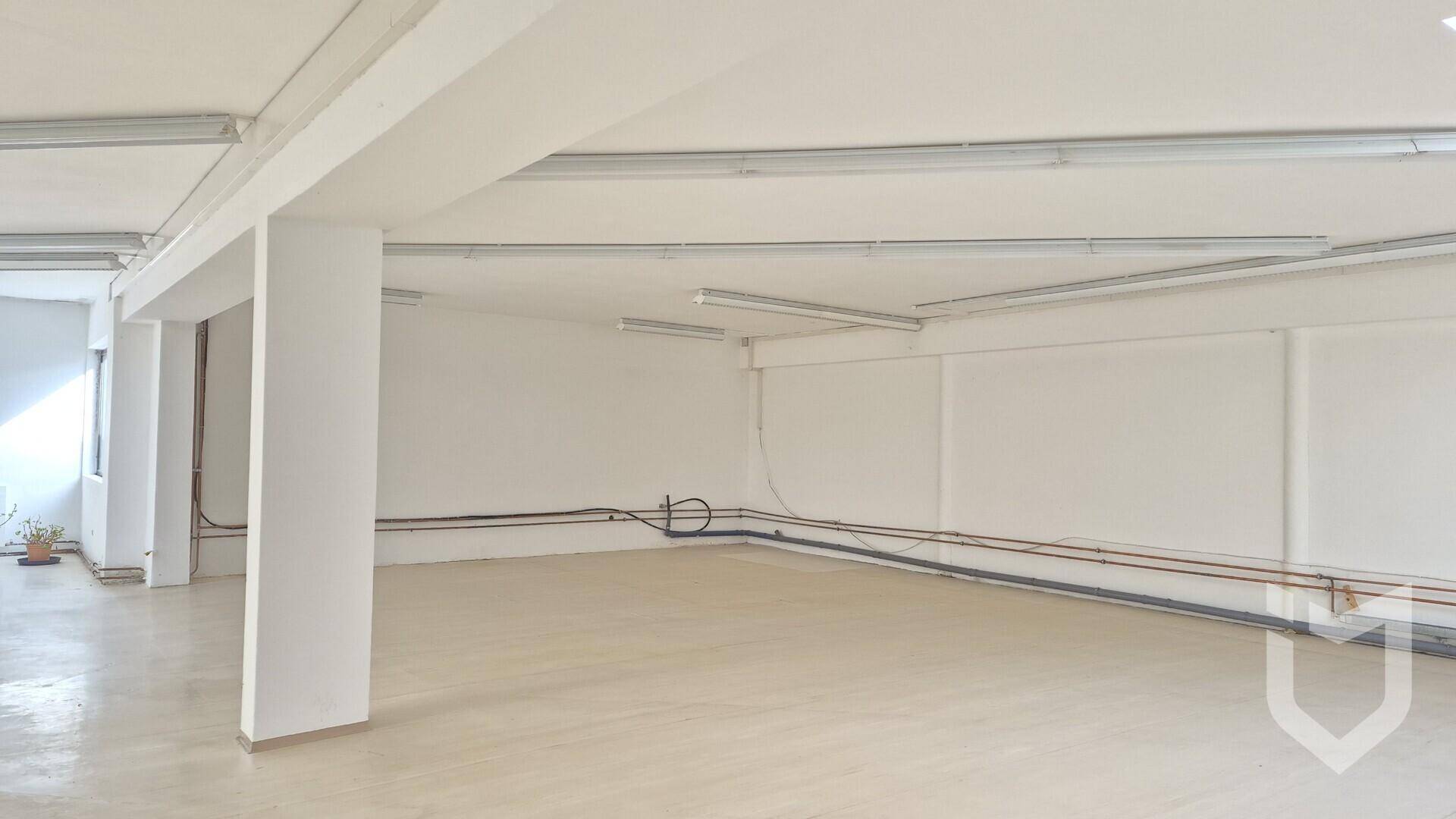 Geräumiger Gewerberaum mit Stützpfeilern, sichtbaren Leitungen und hellen Wänden.