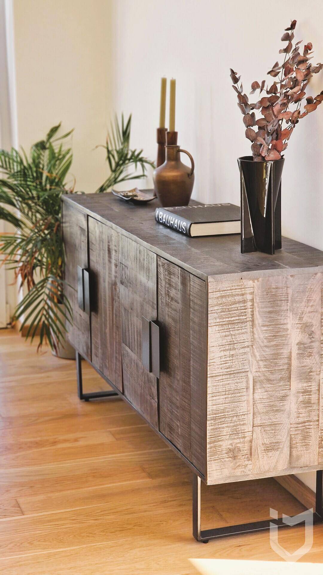 Modernes Sideboard aus Holz mit Dekoration in einem hellen Innenraum.