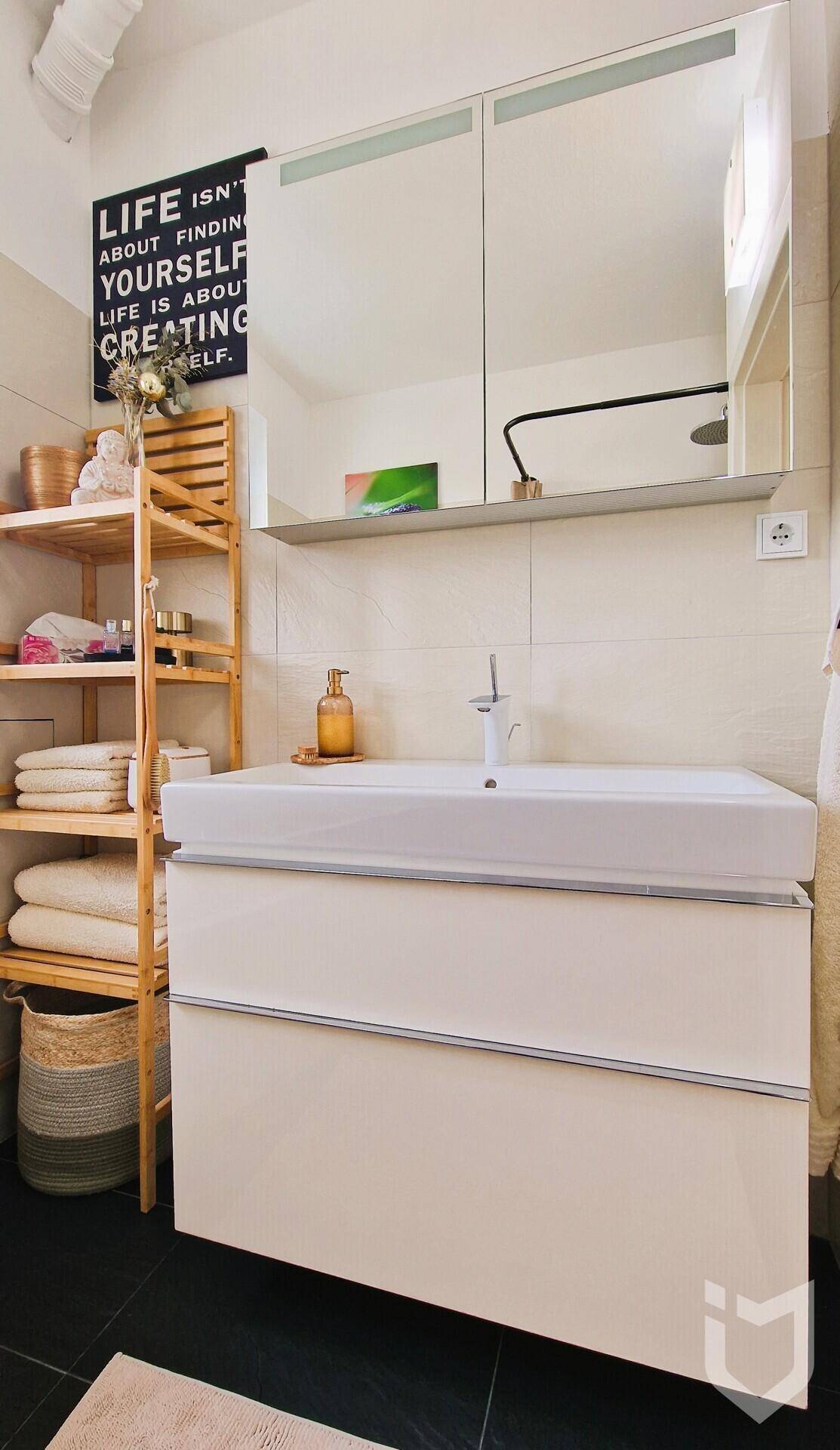 Badezimmer-Waschtisch mit modernem Waschbecken und einem Spiegelschrank darüber.