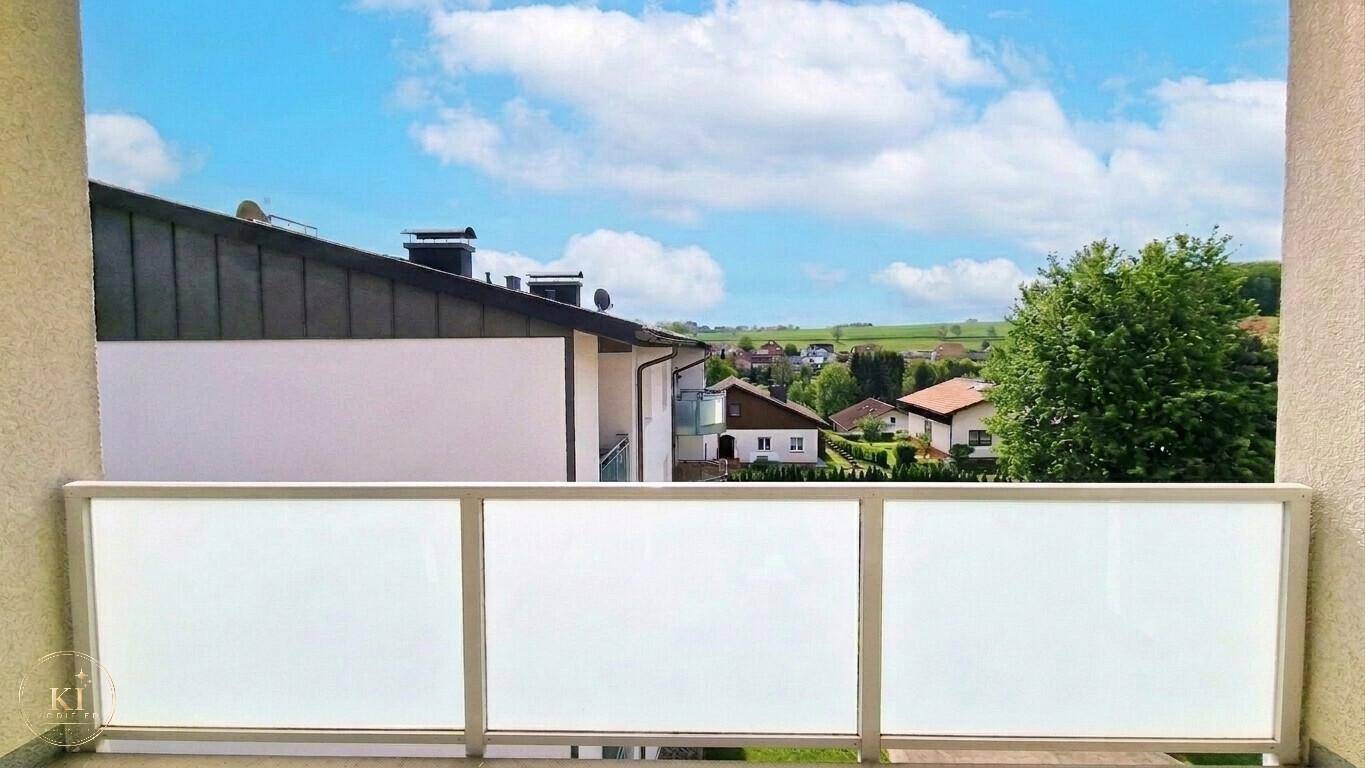 Weitblick vom Balkon über die umliegende Wohnsiedlung und grüne Landschaft.