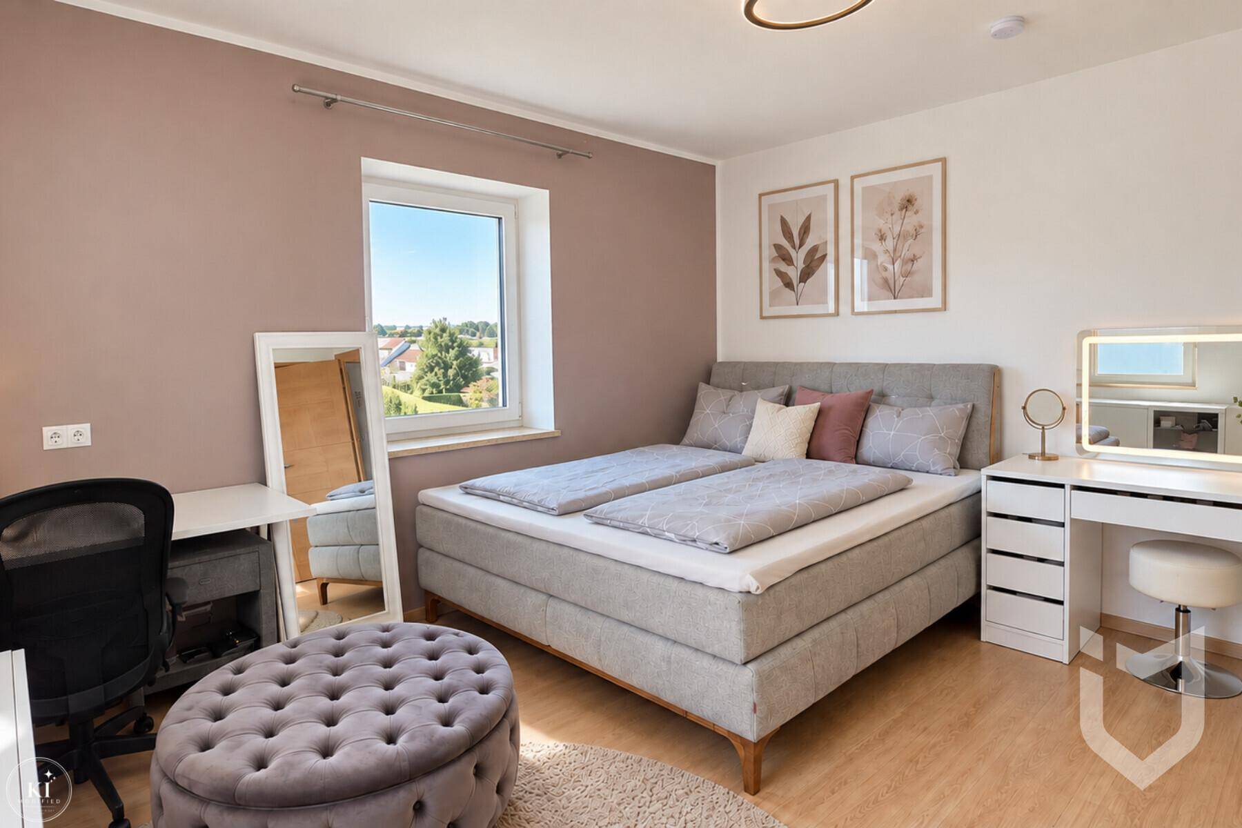 Helles Schlafzimmer mit Doppelbett, Schminktisch und Blick ins Grüne.