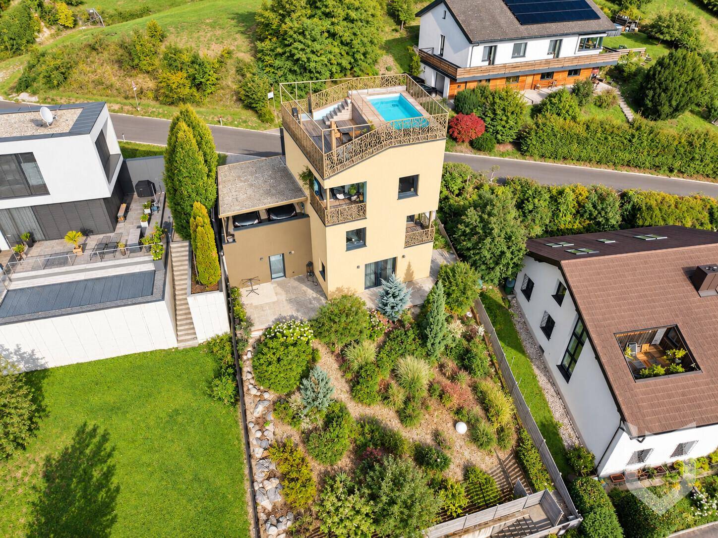 Vogelperspektive des Hauses mit Dachpool, Garten und umliegender Wohnbebauung.