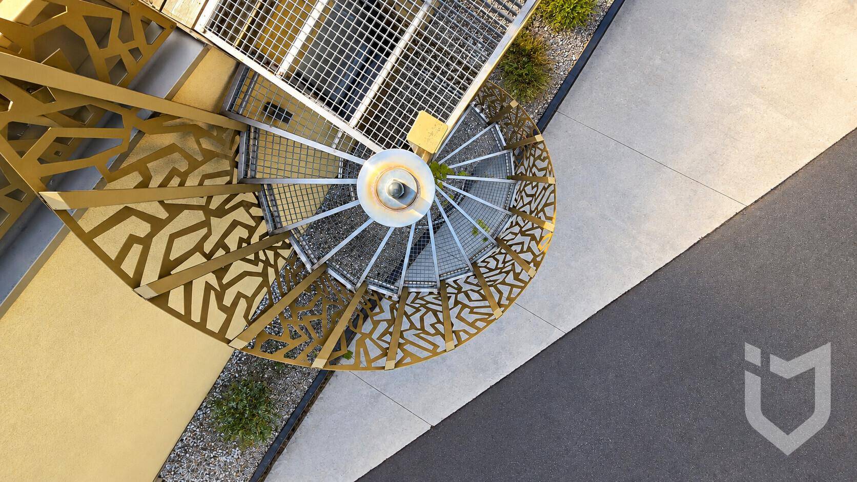 Spiralwendeltreppe mit dekorativem Geländer, die zu den oberen Ebenen führt.