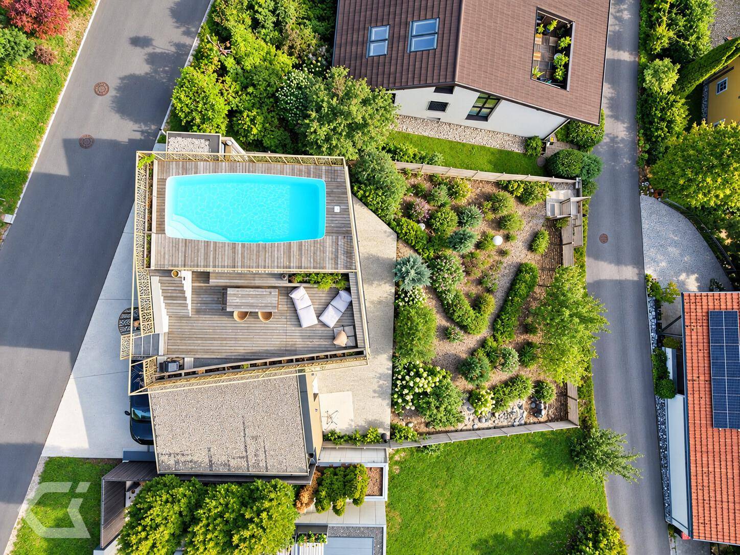 Top-Down-Ansicht des Dachpools und des gepflegten Gartens mit vielfältiger Bepflanzung.