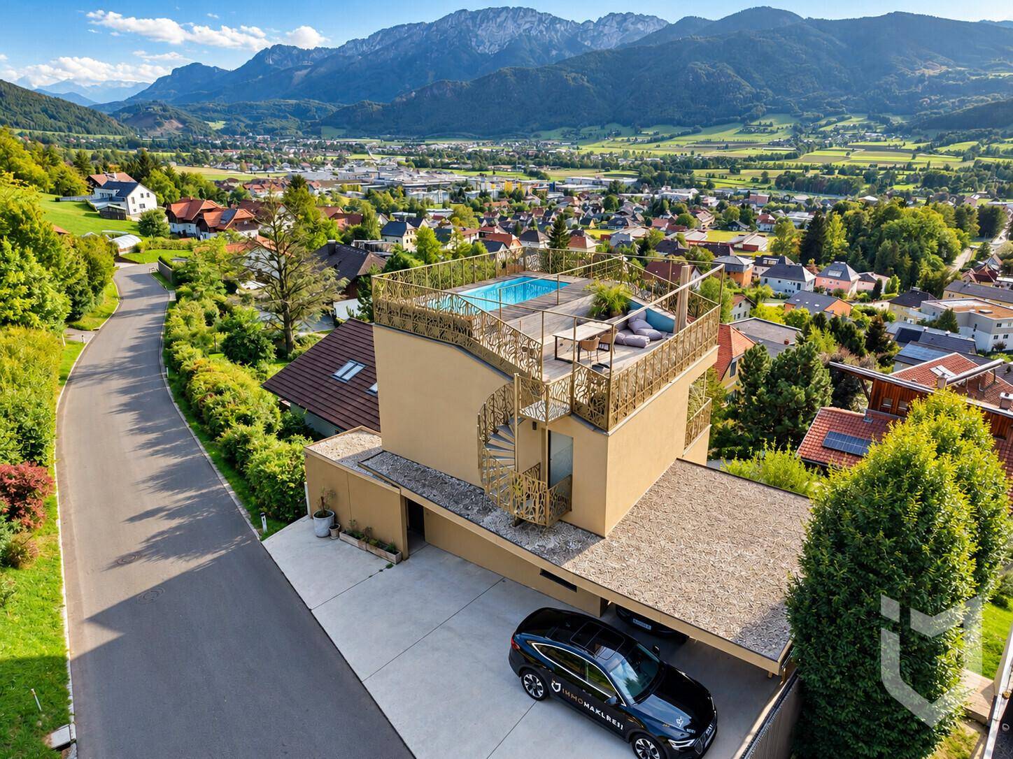 Luftaufnahme des modernen Hauses mit Dachpool und atemberaubendem Bergblick.