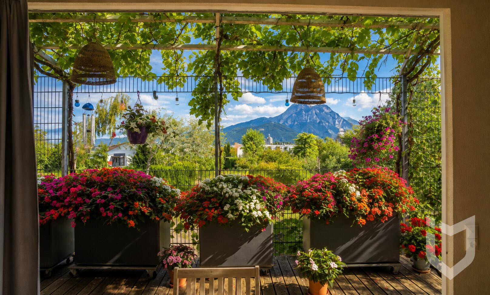 Überdachte Terrasse mit üppigen Blumenkästen und malerischem Bergblick.