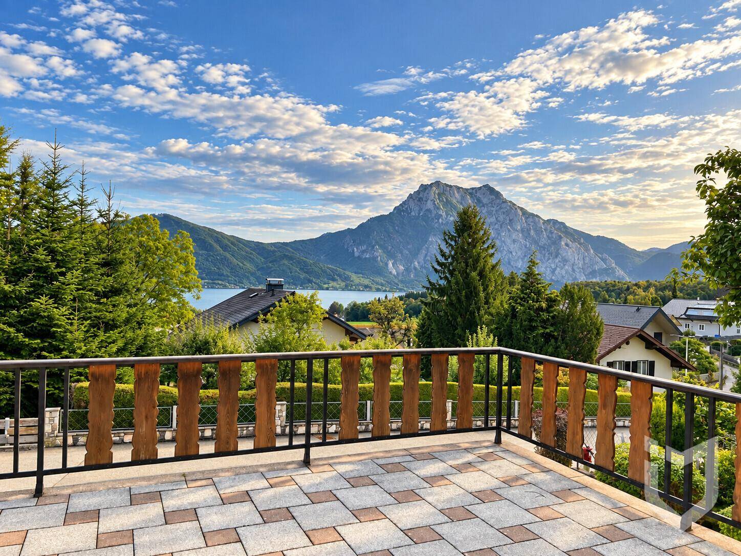 Große geflieste Terrasse mit Holzgeländer und atemberaubendem Panoramablick auf See und Berge.