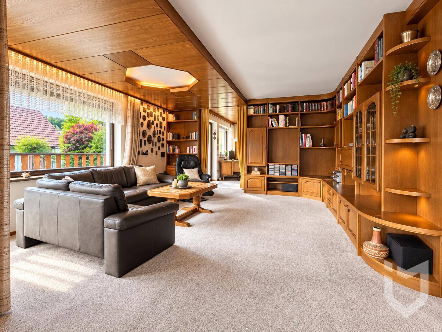 Gemütliches Wohnzimmer mit Teppichboden, Holzdecke und einer großen, eingebauten Bücherwand.