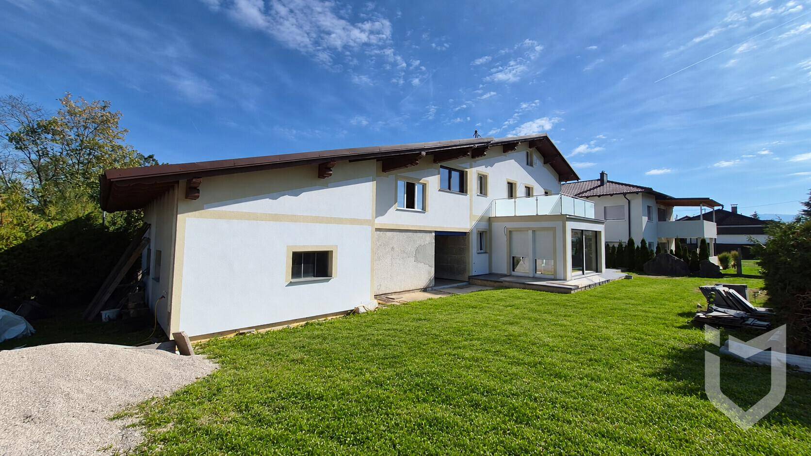 Weitläufige Außenansicht des Hauses mit großem Garten und sonnigem Wetter.