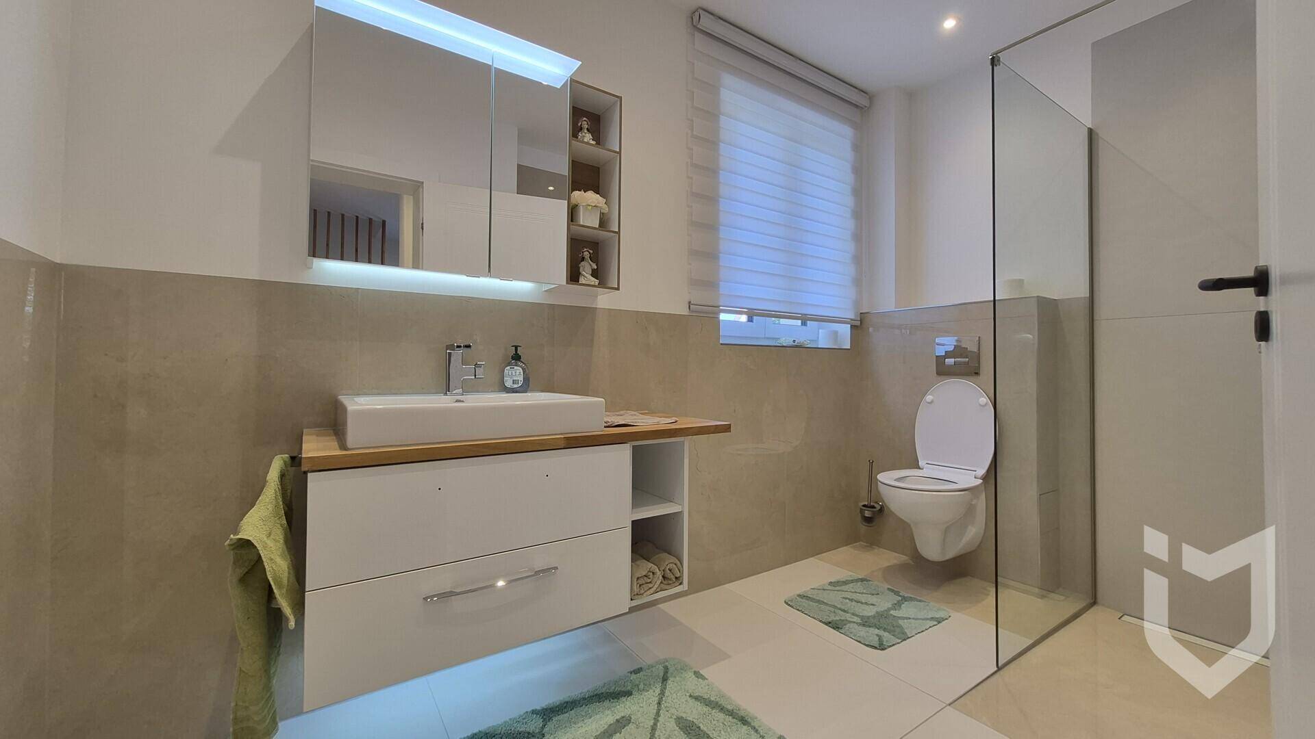 Modernes Badezimmer mit begehbarer Dusche, Wand-WC und Fenster.