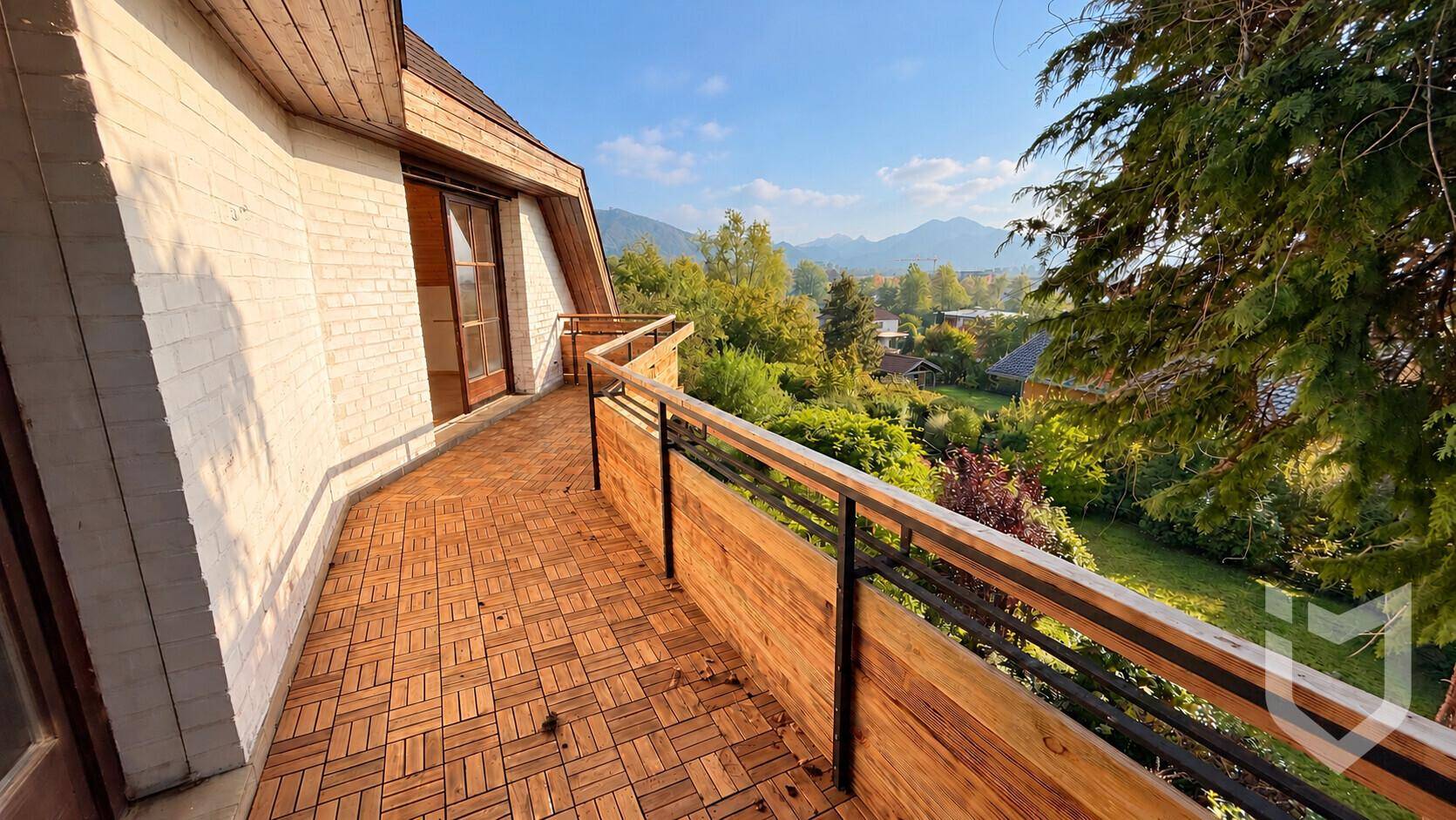 Großer Balkon mit Holzboden und weitem Blick auf die Berge.
