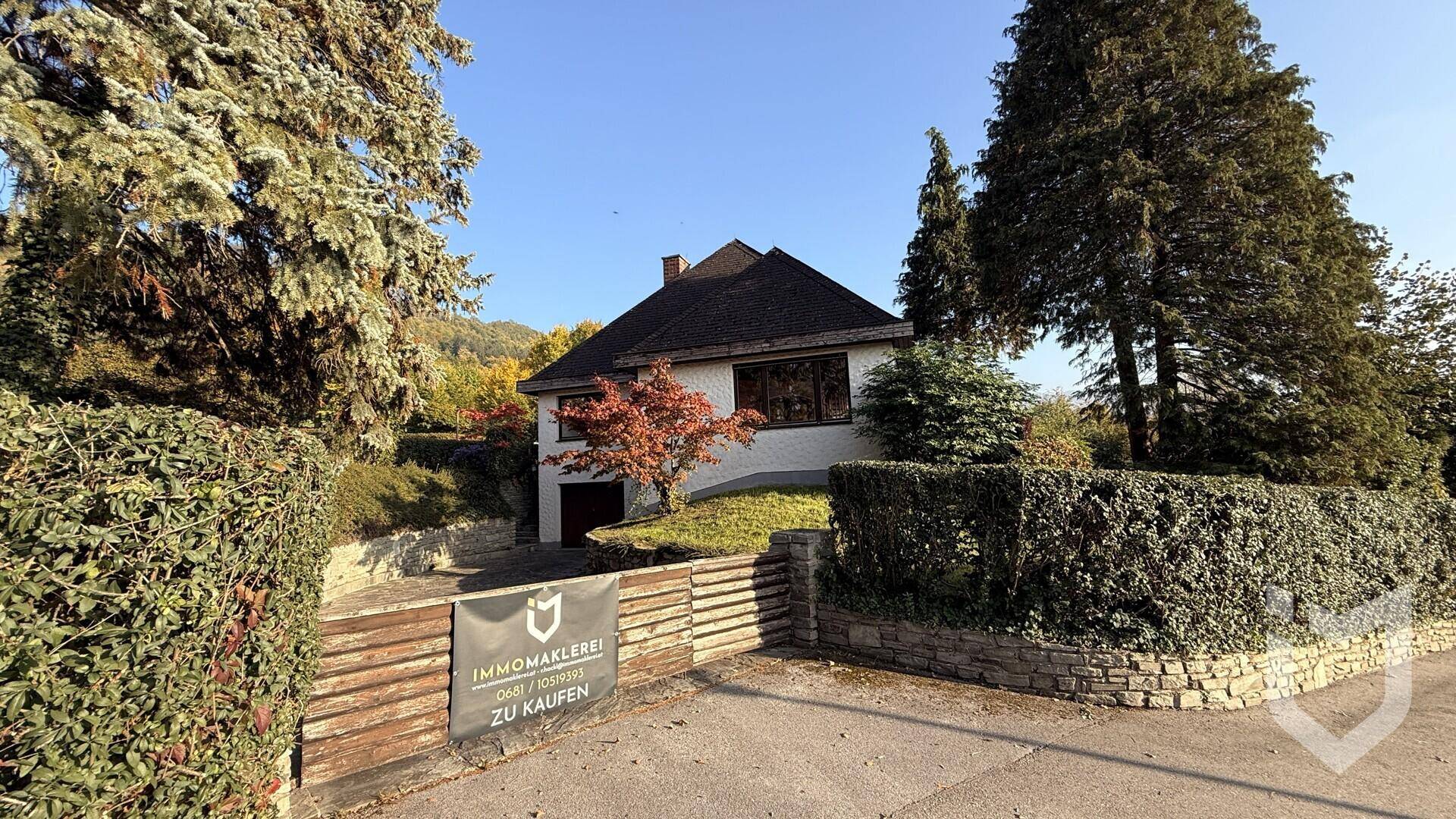 Ansicht des Hauses von der Straße mit umzäuntem Vorgarten.
