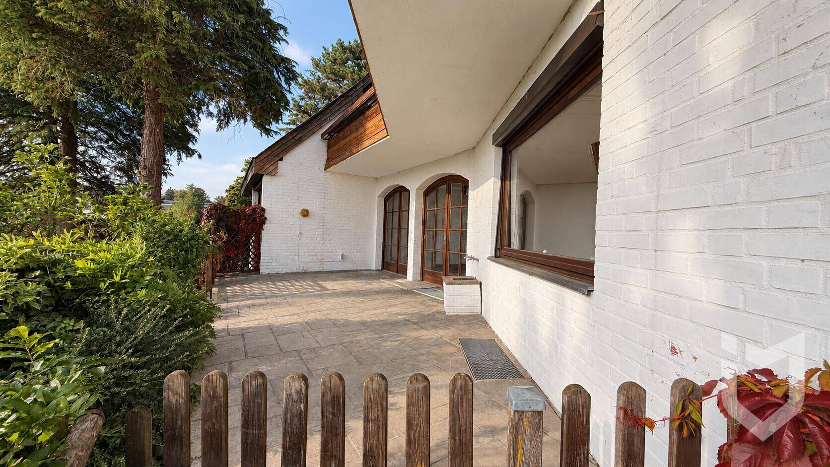Geräumige Steinterrasse am Haus mit Zugang zum Garten.
