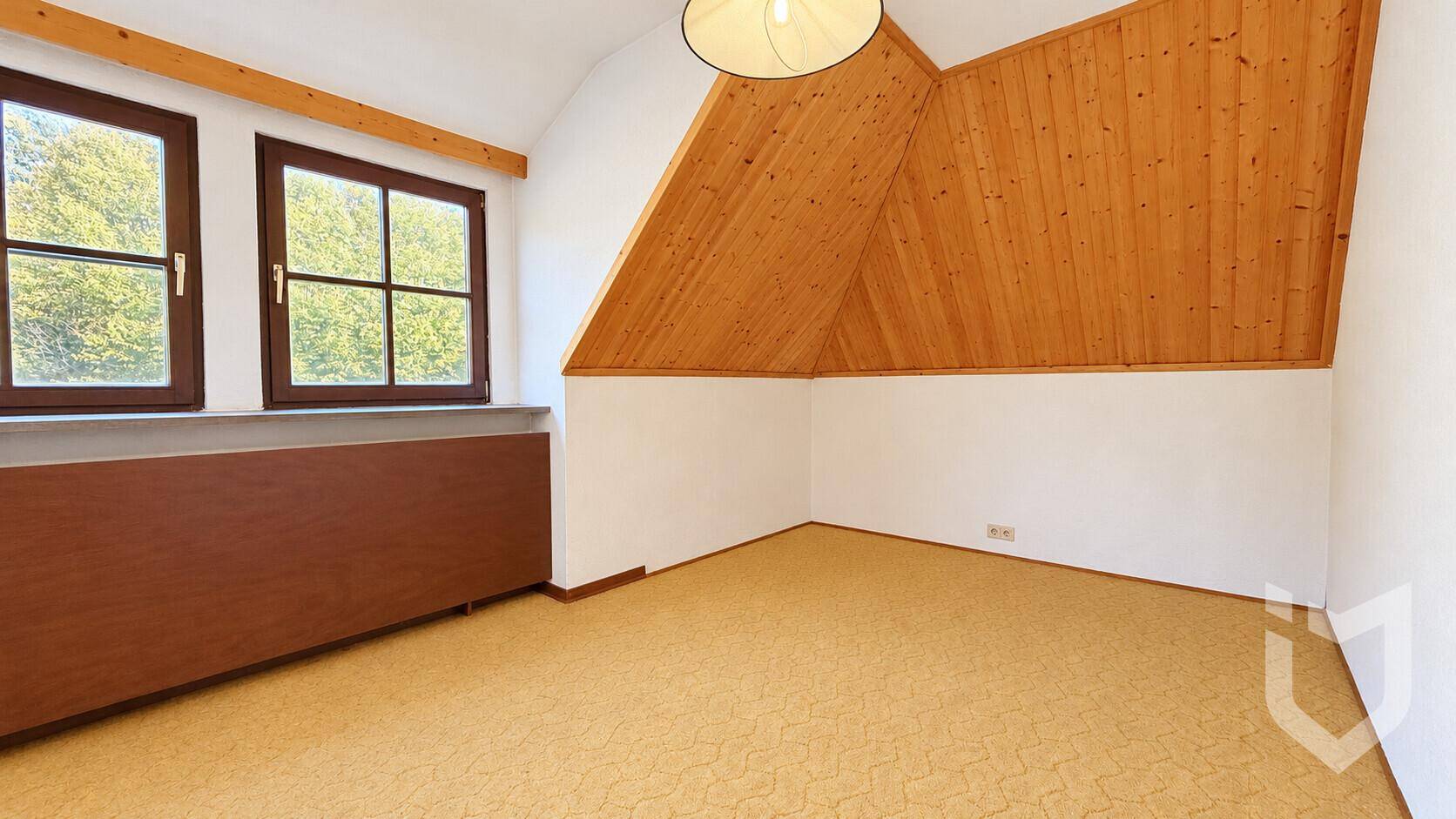 Schlafzimmer mit Teppichboden, Holzdecke und Fenster mit Ausblick.