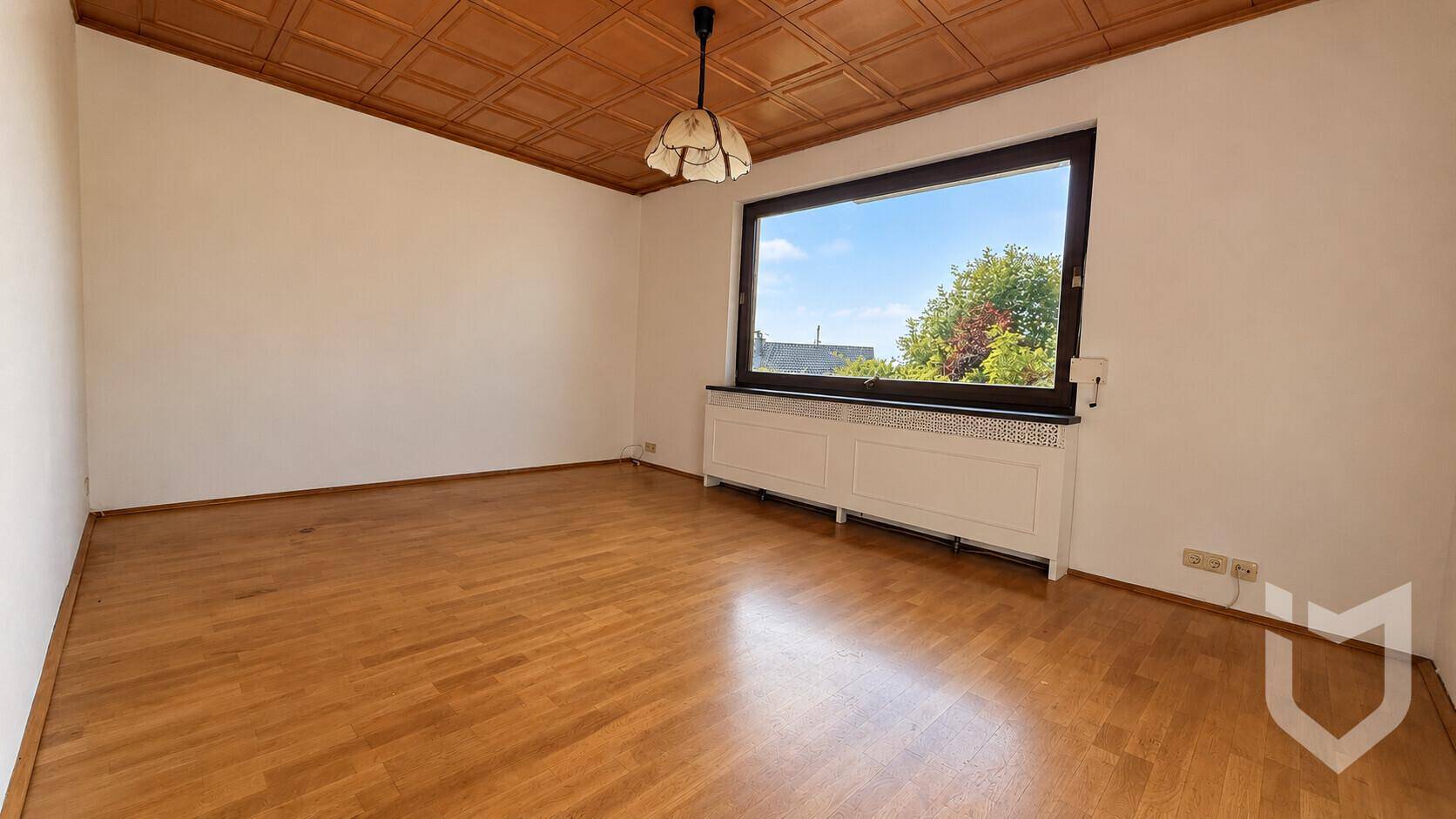 Helles Schlafzimmer mit Holzboden und großem Fenster mit Ausblick.
