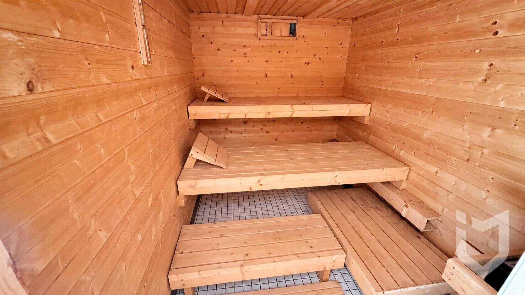 Holzsauna mit mehreren Bänken für Entspannung und Wellness.