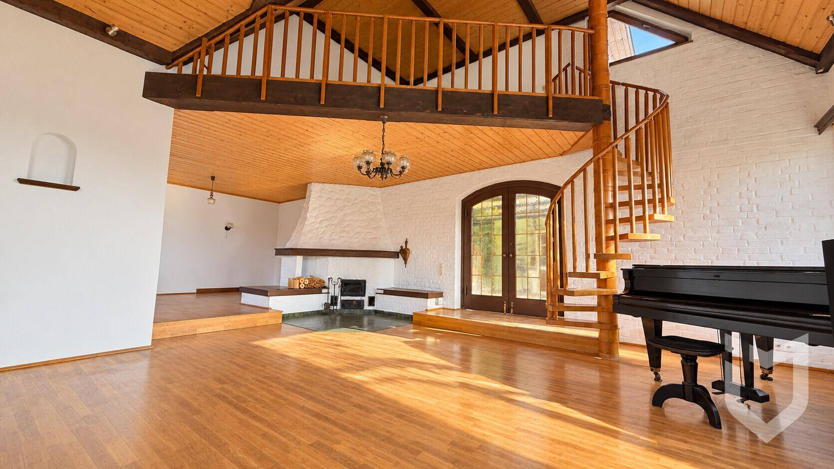 Geräumiges Wohnzimmer mit Holzdecke, Wendeltreppe und Kaminbereich.