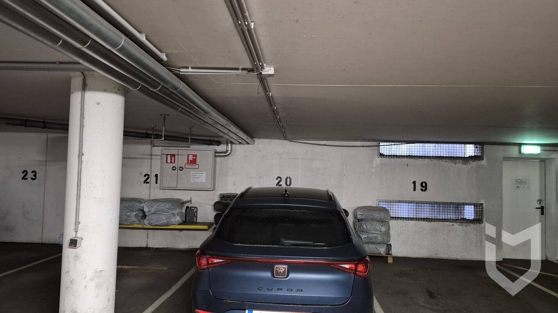 Tiefgarage mit einem geparkten Auto und nummerierten Stellplätzen.