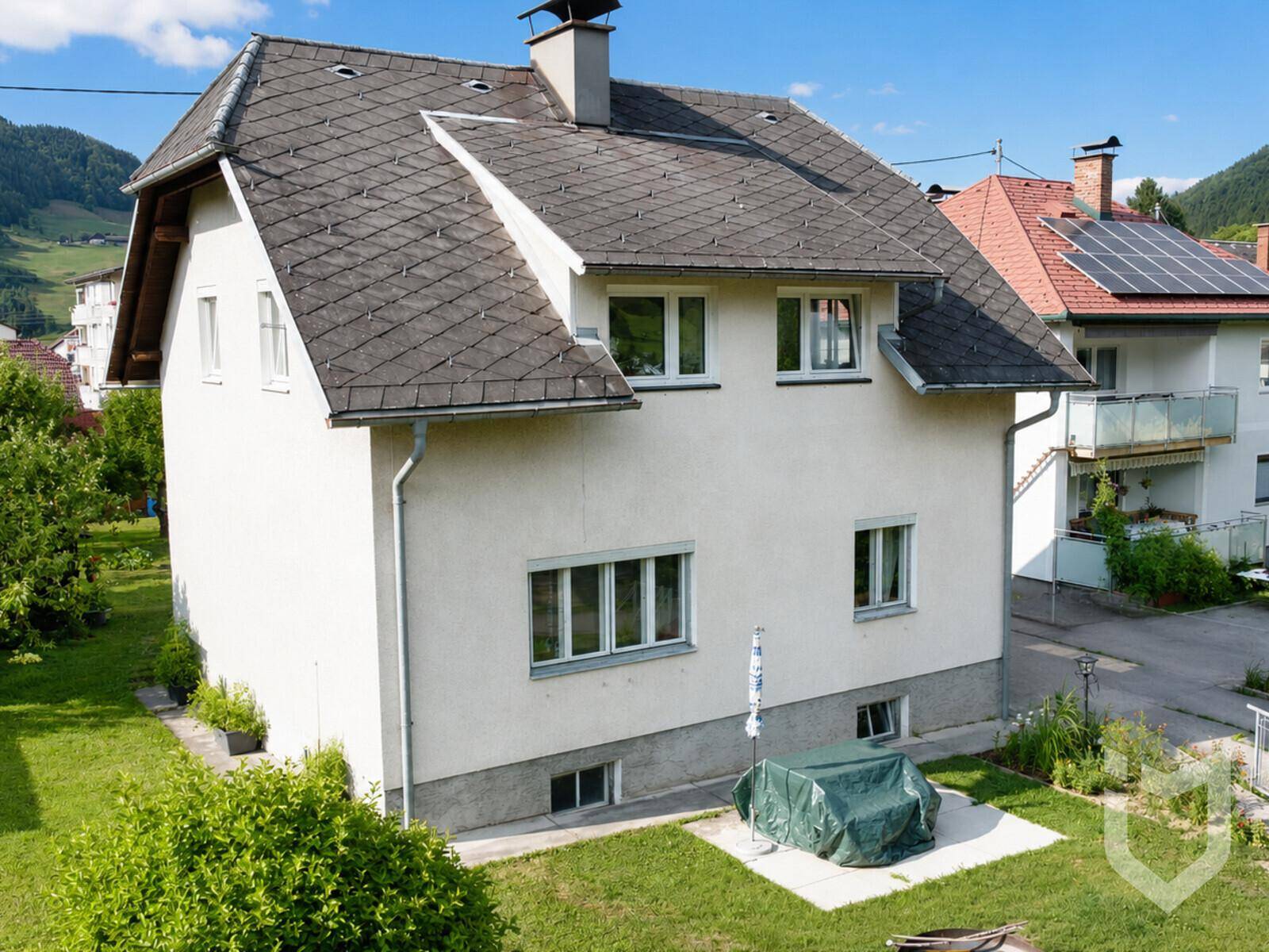 Seitenansicht des Einfamilienhauses mit gepflegtem Gartenbereich und Satteldach.