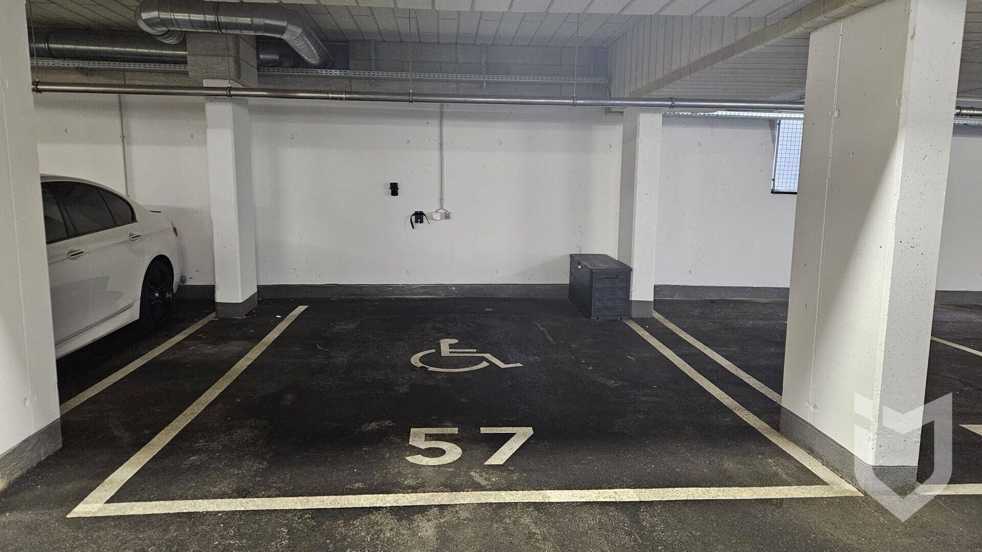 Tiefgaragenstellplatz, behindertengerecht markiert, mit ausreichend Platz für ein Fahrzeug.