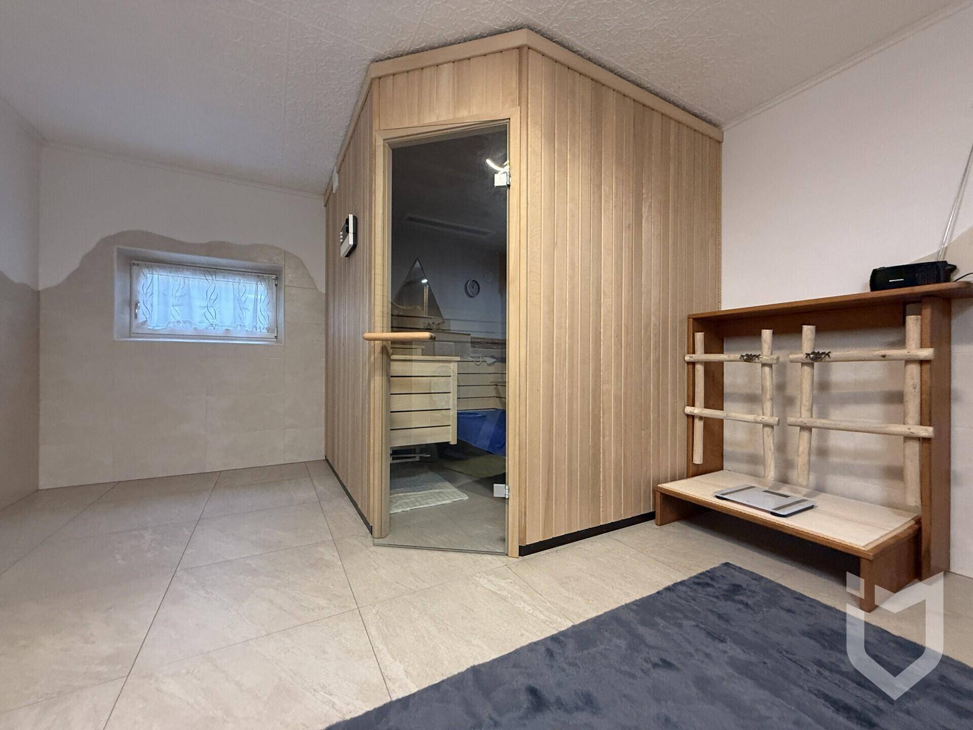 Geräumiger Raum mit einer modernen Holzsauna und Fliesenboden für Entspannung.