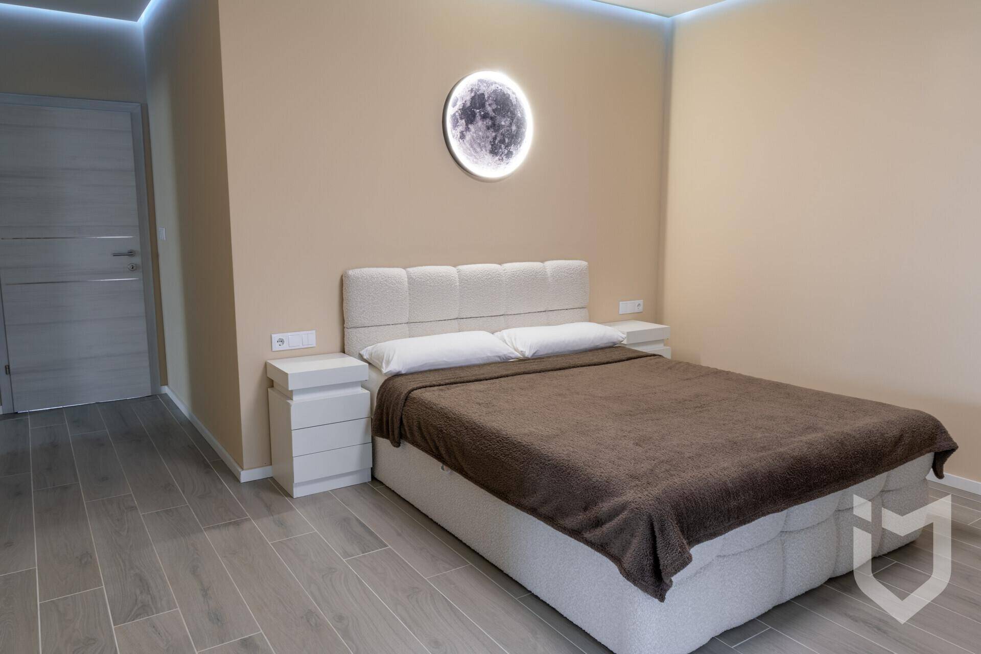 Gemütliches Schlafzimmer mit Doppelbett, Nachttischen und indirekter Deckenbeleuchtung.
