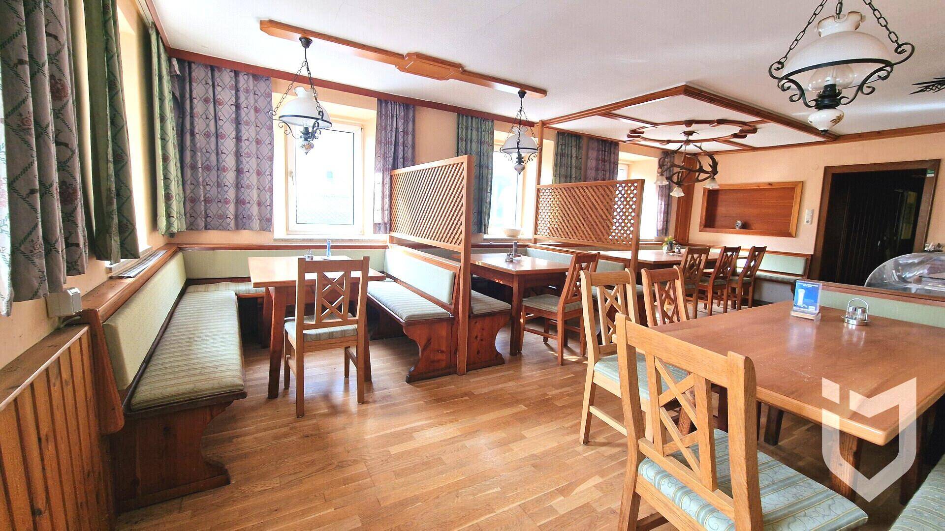 Gemütlicher Essbereich mit Holztischen, Bänken und traditioneller Einrichtung.