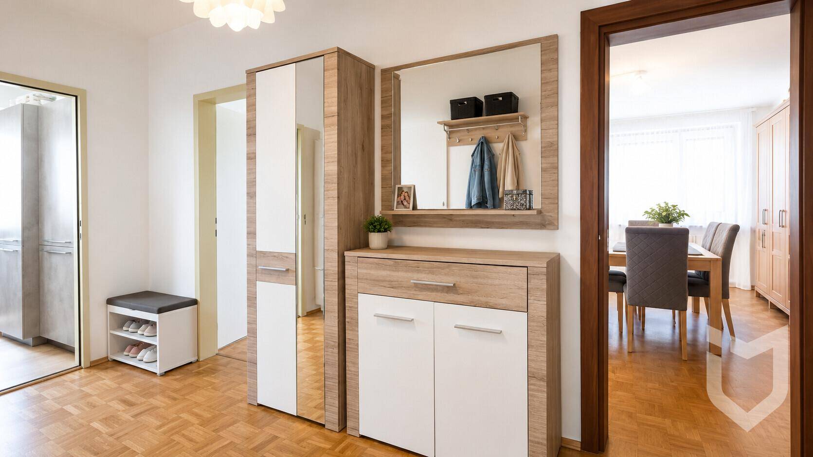 Heller Flur mit Parkettboden, modernem Schuhschrank und großem Spiegel.