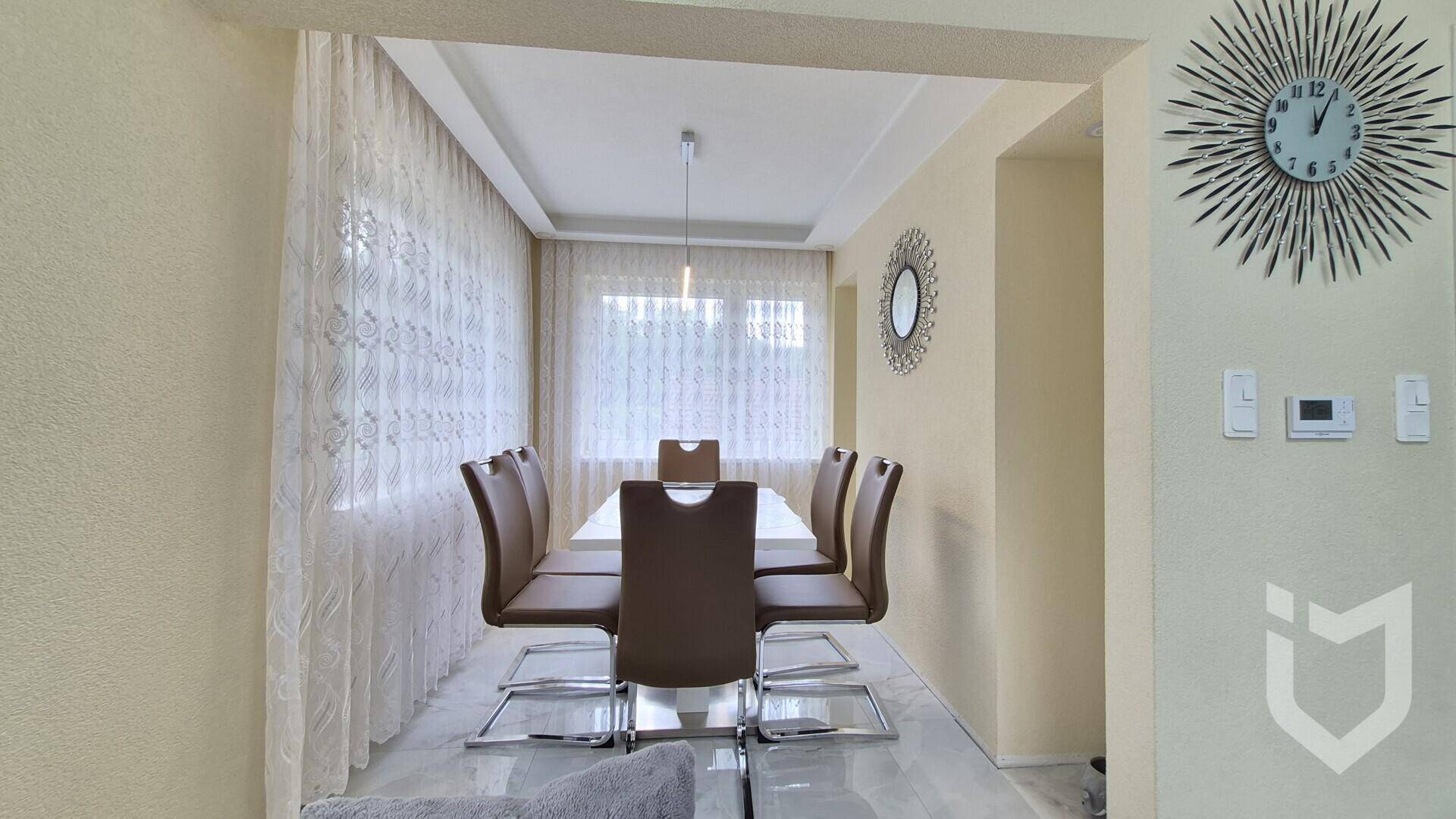 Eleganter Essbereich mit großem Tisch und modernen Stühlen, hell und mit viel Tageslicht.