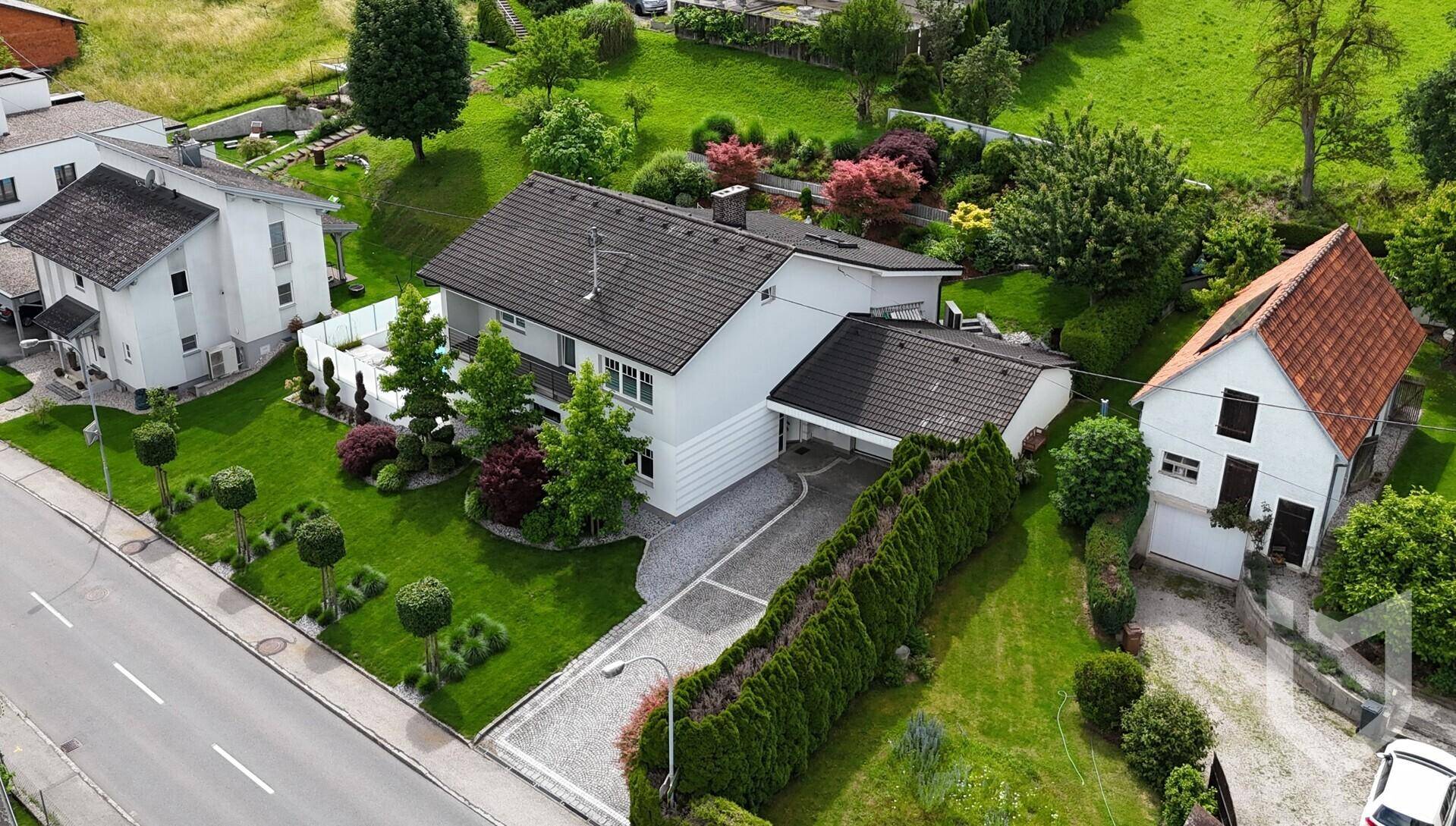Luftaufnahme des Einfamilienhauses mit gepflegtem Garten und umliegender Wohnbebauung.