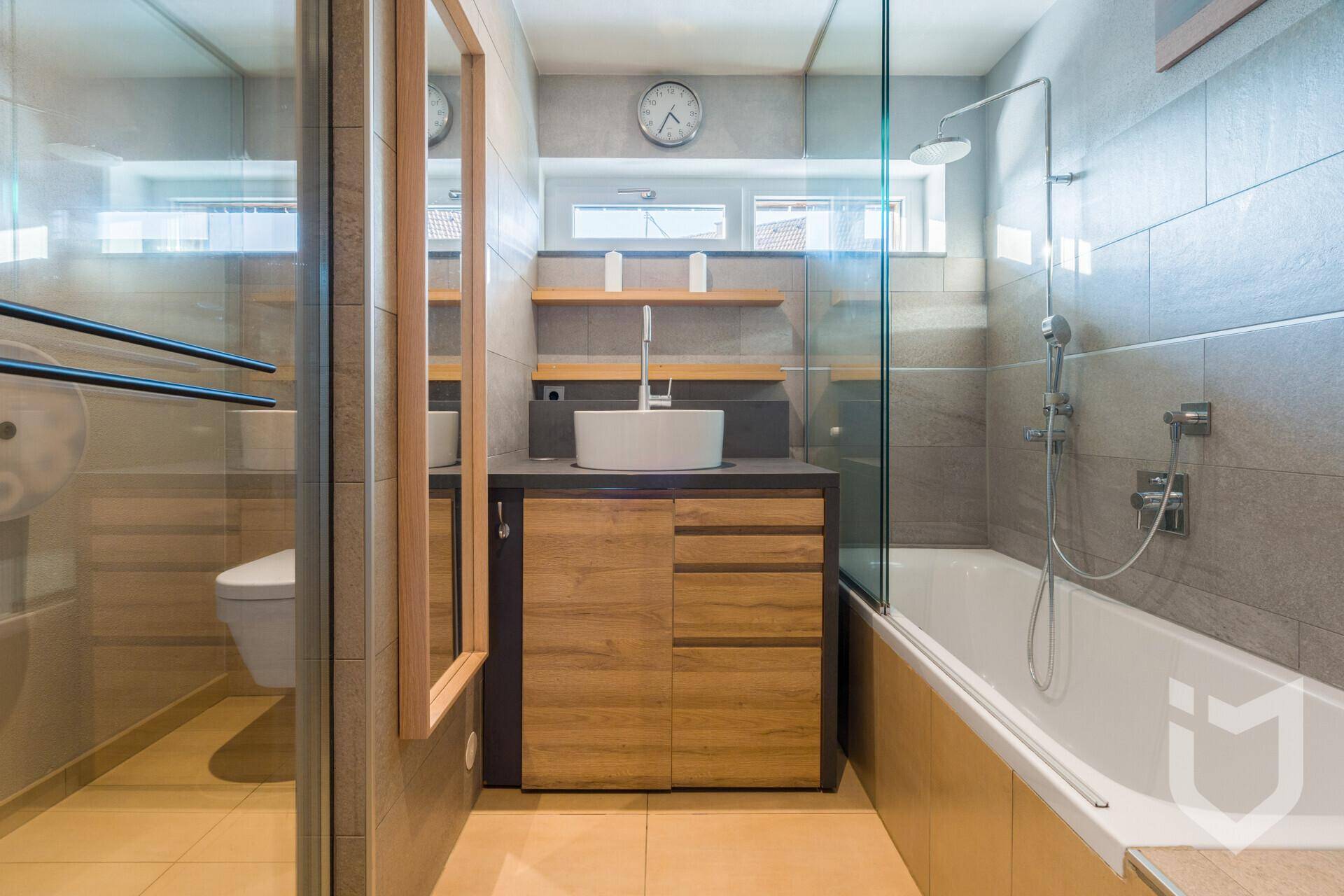 Modernes Badezimmer mit Badewanne, Dusche, Einzelwaschbecken und Fenster.