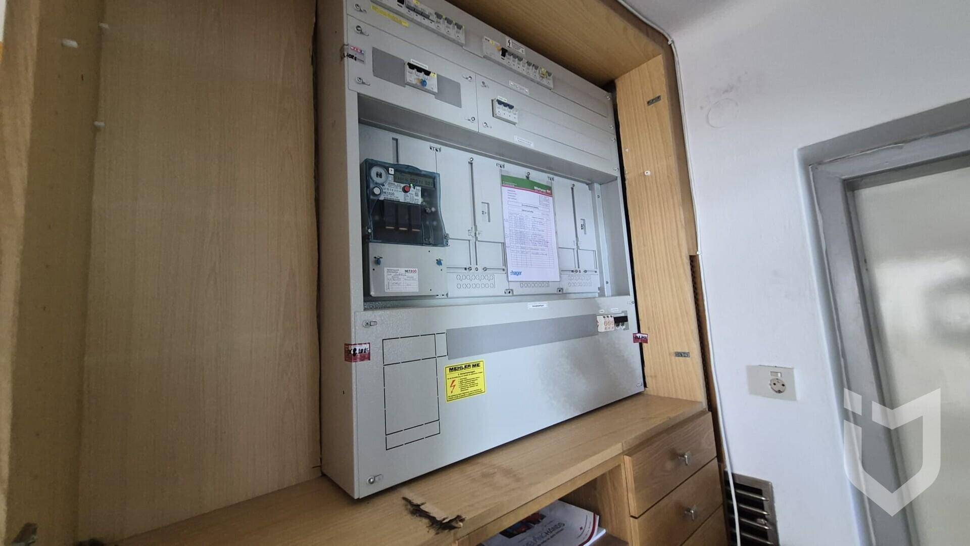 Moderner Sicherungskasten und Elektroverteilung in einem Holzschrank verbaut.