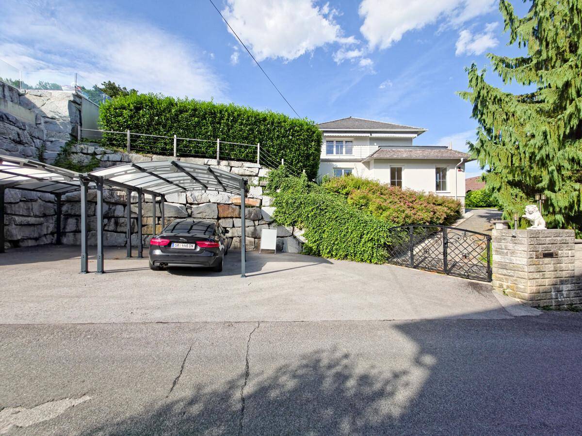 Einfahrt mit Carport für ein Fahrzeug und Zugang zum Grundstück.