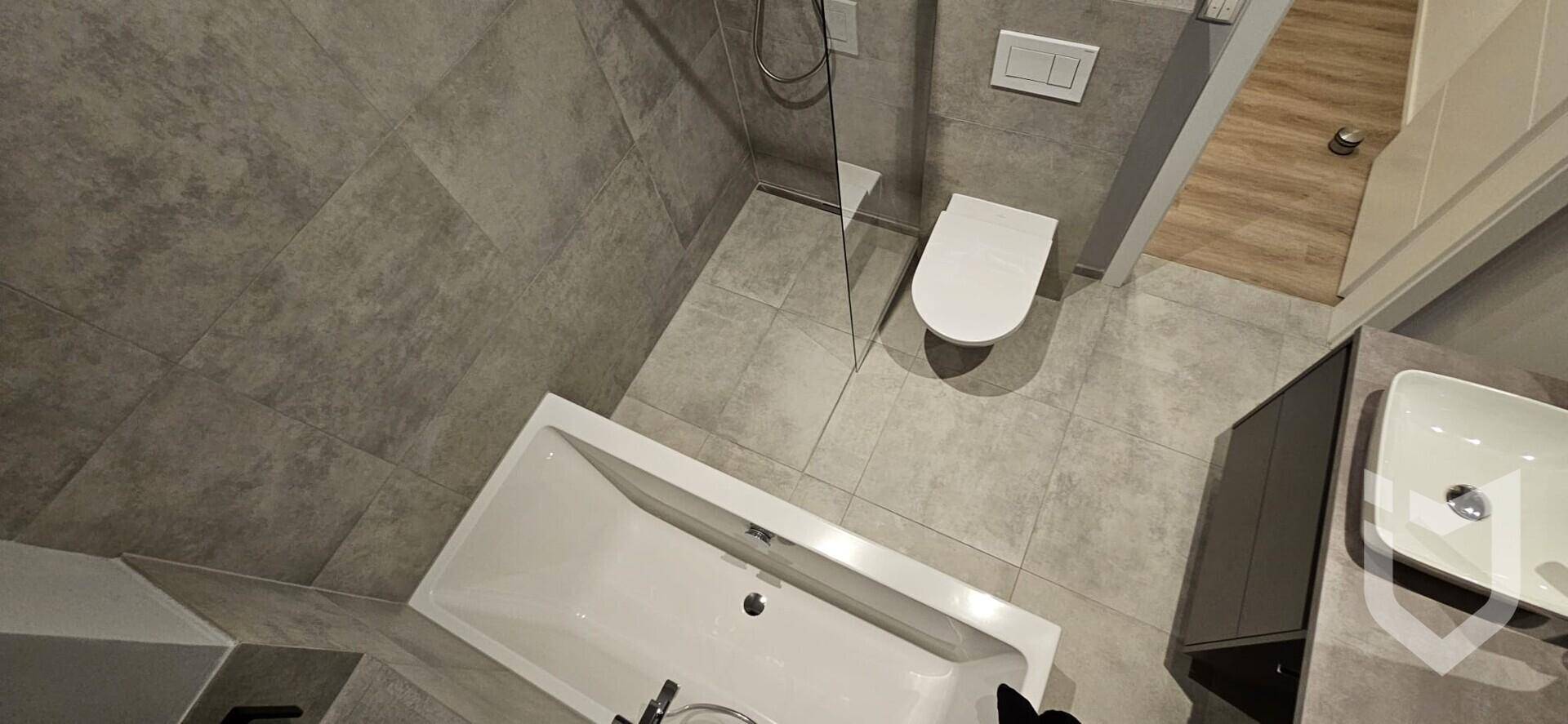 Modernes Badezimmer von oben gesehen mit Badewanne, Toilette und Duschbereich.