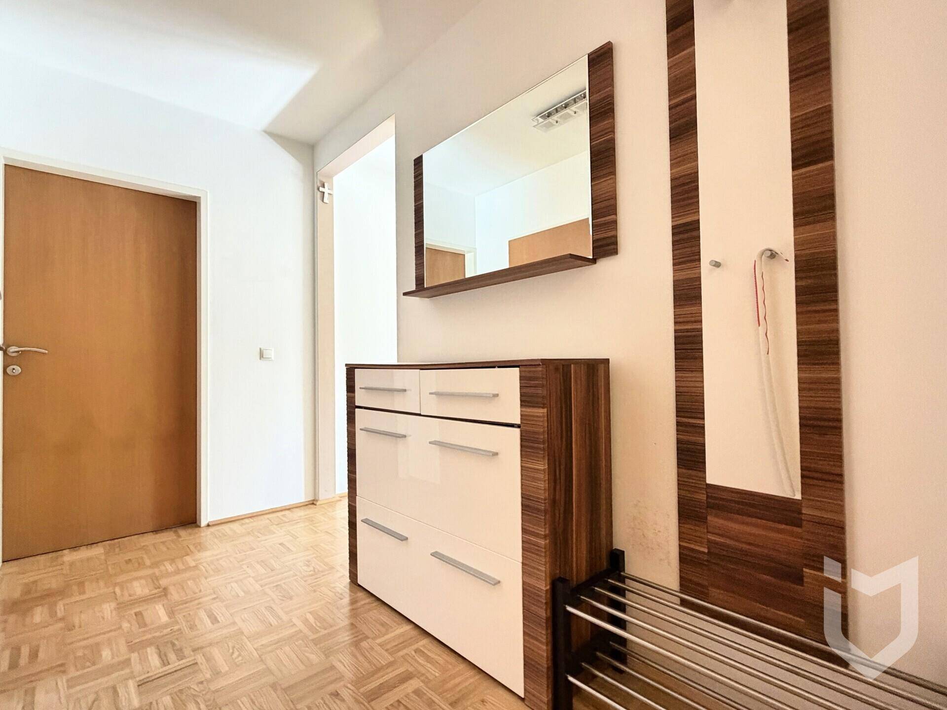 Flur mit modernem Schuhschrank, Spiegel und Garderobe, ausgestattet mit Parkettboden.