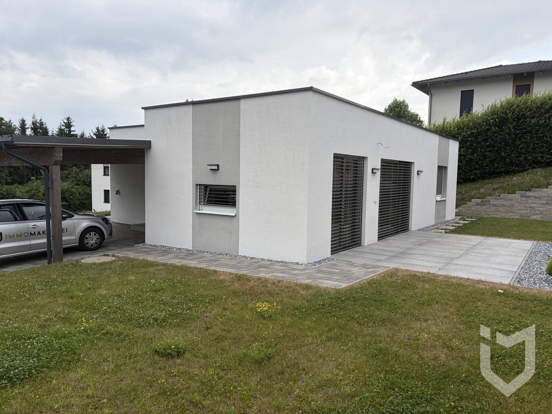 Modernes Einfamilienhaus mit Flachdach, Carport und gepflegtem Gartenbereich in ruhiger Lage.