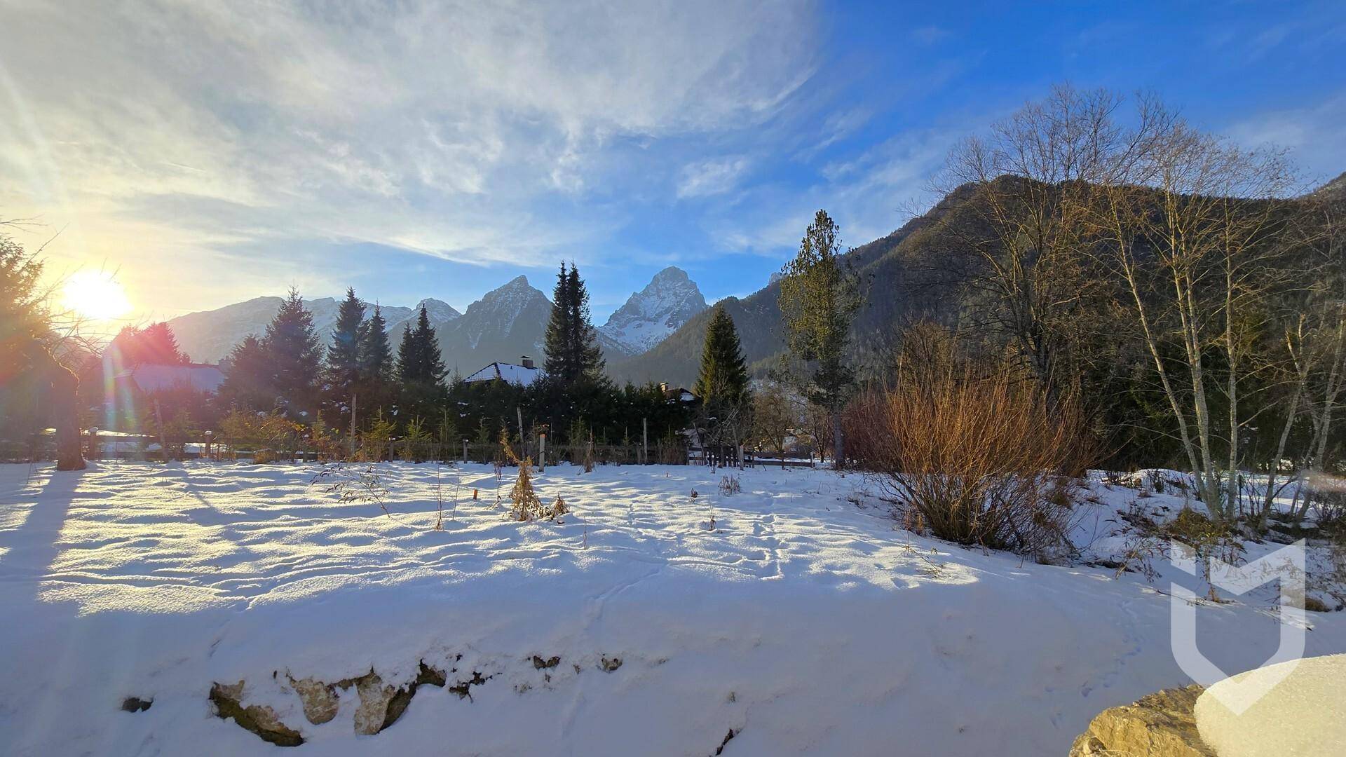 Weitläufiges, schneebedecktes Grundstück mit beeindruckendem Blick auf die umliegende Berglandschaft.