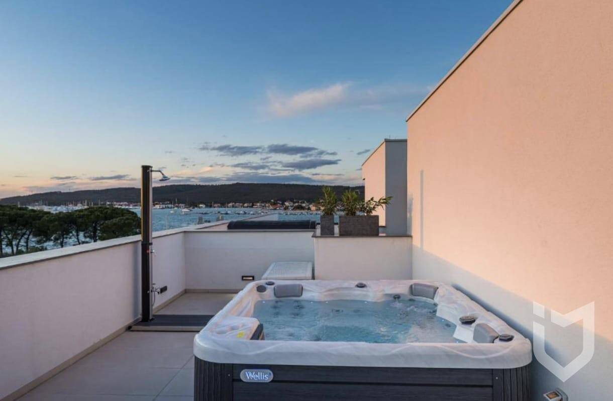 Whirlpool auf der Dachterrasse bei Sonnenuntergang mit malerischem Meerblick.